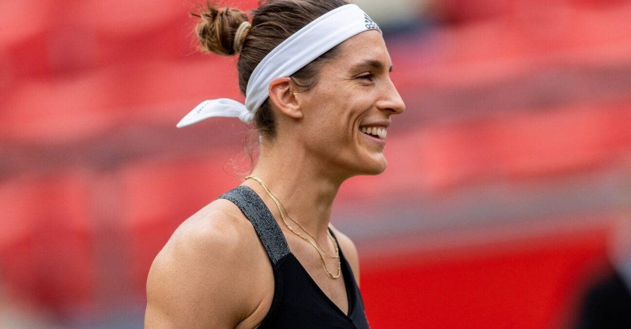 smiling 桌布 壁紙 — 一位微笑的女網球選手，戴著白色頭帶和黑色背心，站在紅色體育場座位前。