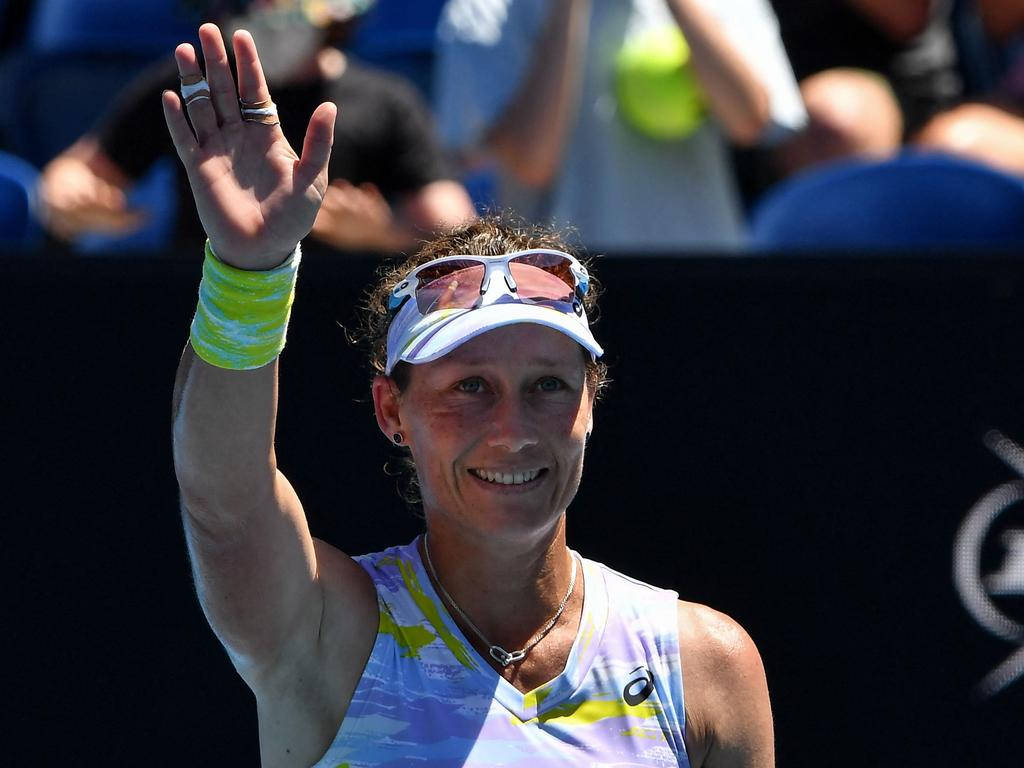Champion 桌布 壁紙 — 一位微笑的女網球選手在明亮陽光下戴著遮陽帽和彩色腕帶向粉絲揮手。