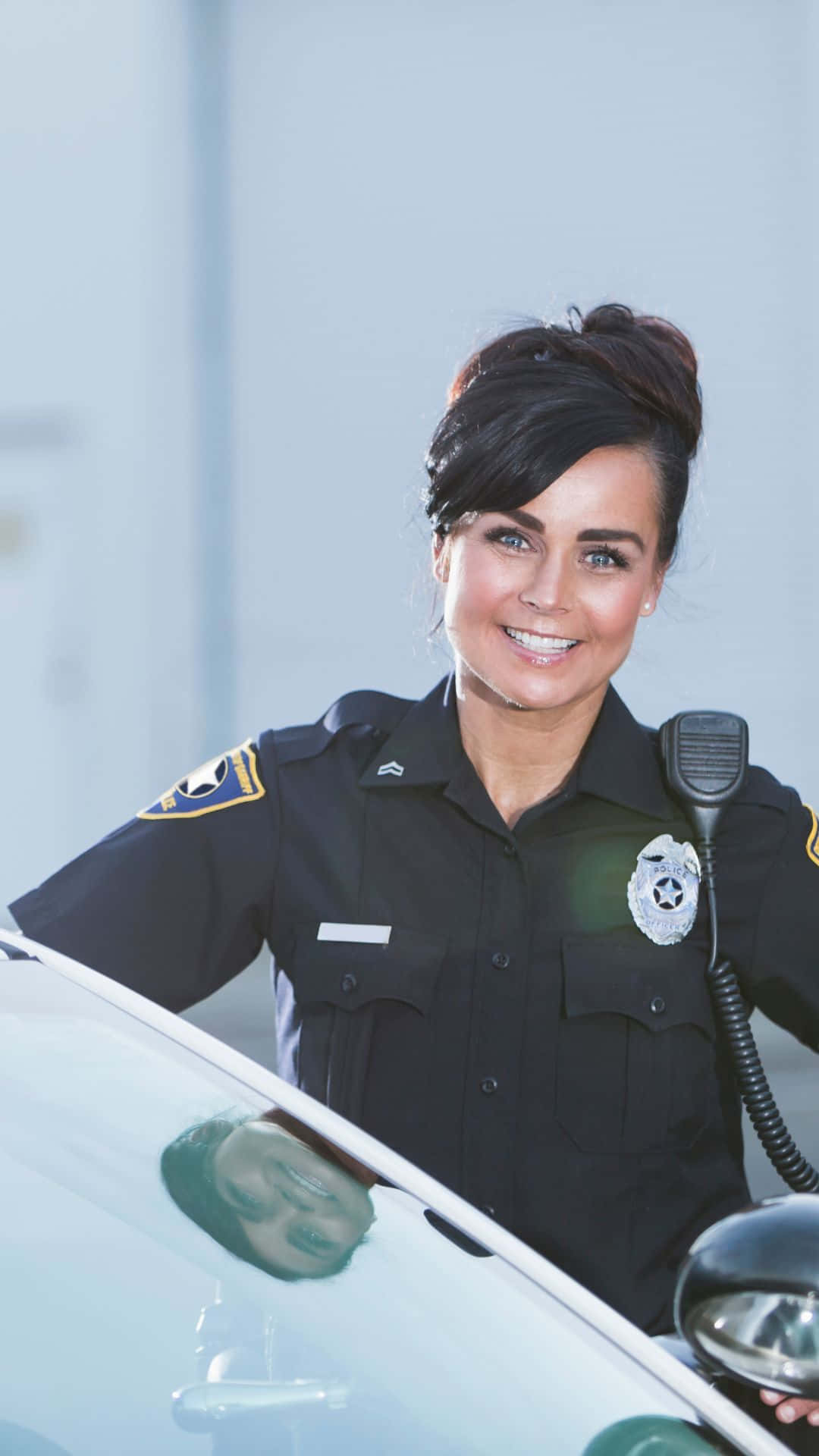 Woman 桌布 壁紙 — 一位微笑的女警在明亮的白天靠著她的巡邏車。