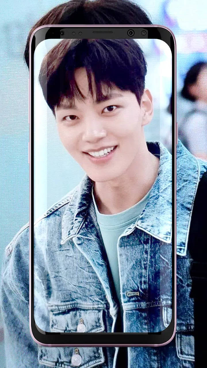 Jin 桌布 壁紙 — 一位微笑的年輕男子穿著牛仔外套，顯示在帶有模糊背景的智慧型手機螢幕上。