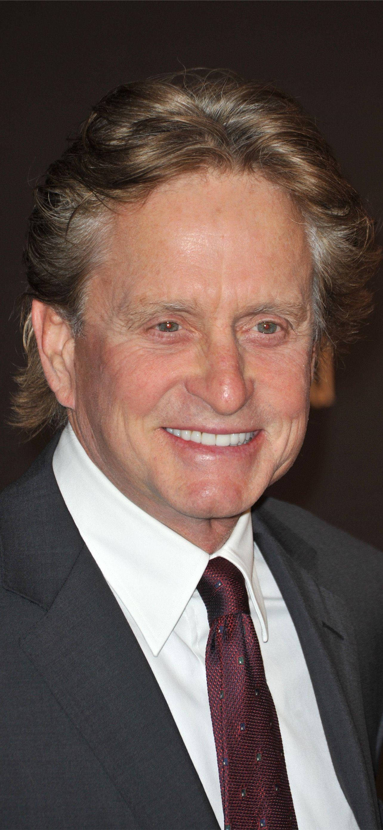 actor 桌布 壁紙 — 一位微笑的年長男士特寫肖像，波浪形頭髮，身穿深色西裝和圖案領帶。
