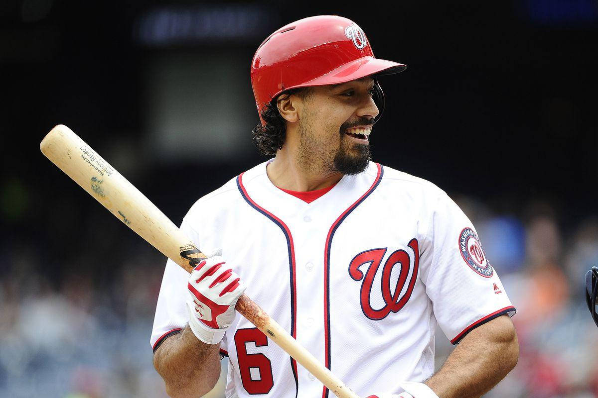 anthony rendon 桌布 壁紙 — 一位微笑的棒球運動員，戴著紅色頭盔，身穿白色制服，手持木製球棒，球衣上印有6號。
