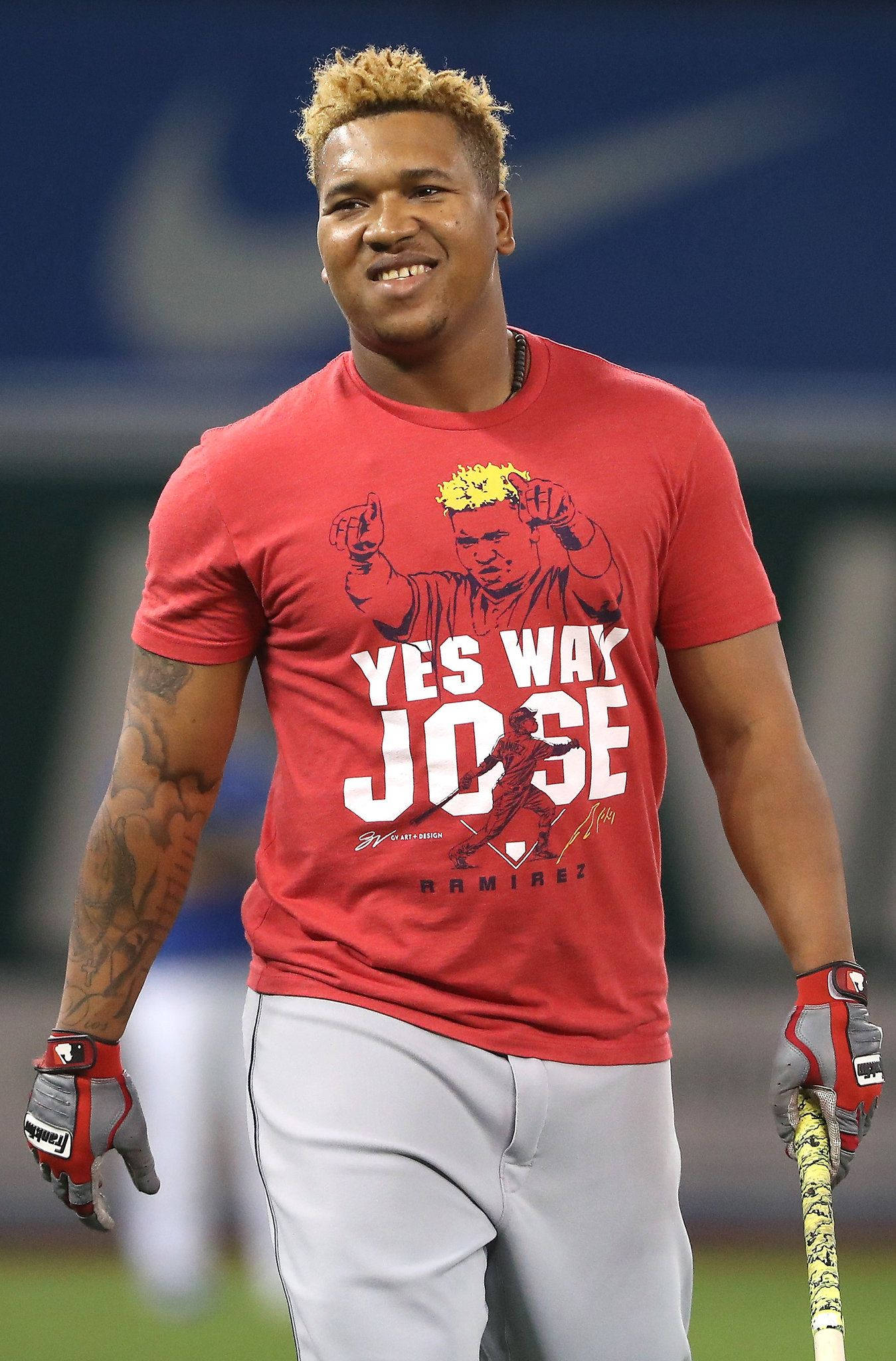 Jose Ramirez 桌布 壁紙 — 一位微笑的棒球運動員穿著紅色 'Yes Way Jose' T恤和打擊手套，站在球場上拿著球棒。