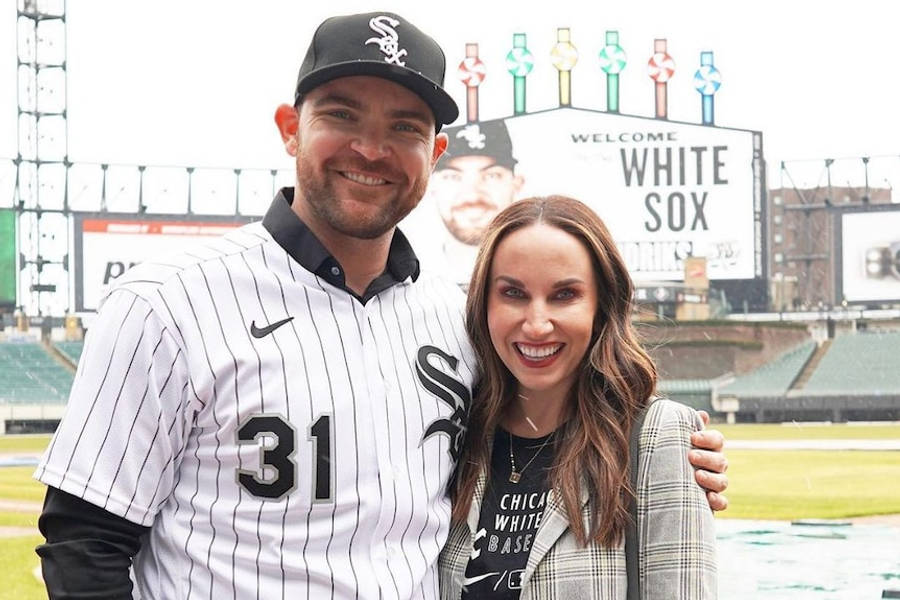 Chicago White Sox 桌布 壁紙 — 一位微笑的棒球運動員身穿白襪隊制服，與一位女士在球場上合影，背景是「Welcome White Sox」標語牌。