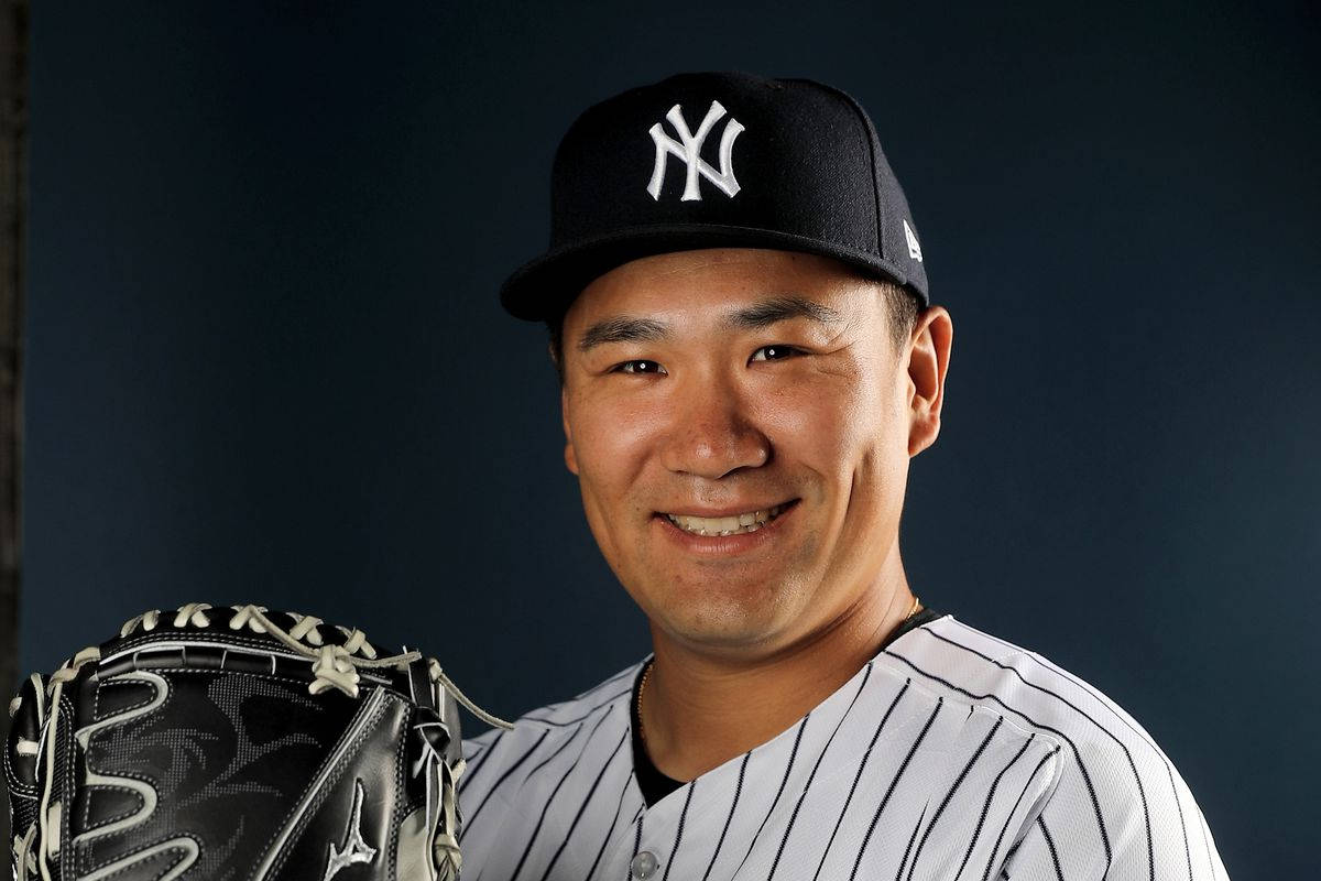 masahiro tanaka 桌布 壁紙 — 一位微笑的棒球運動員身穿紐約洋基隊制服，在黑暗的攝影棚背景下拿著手套。