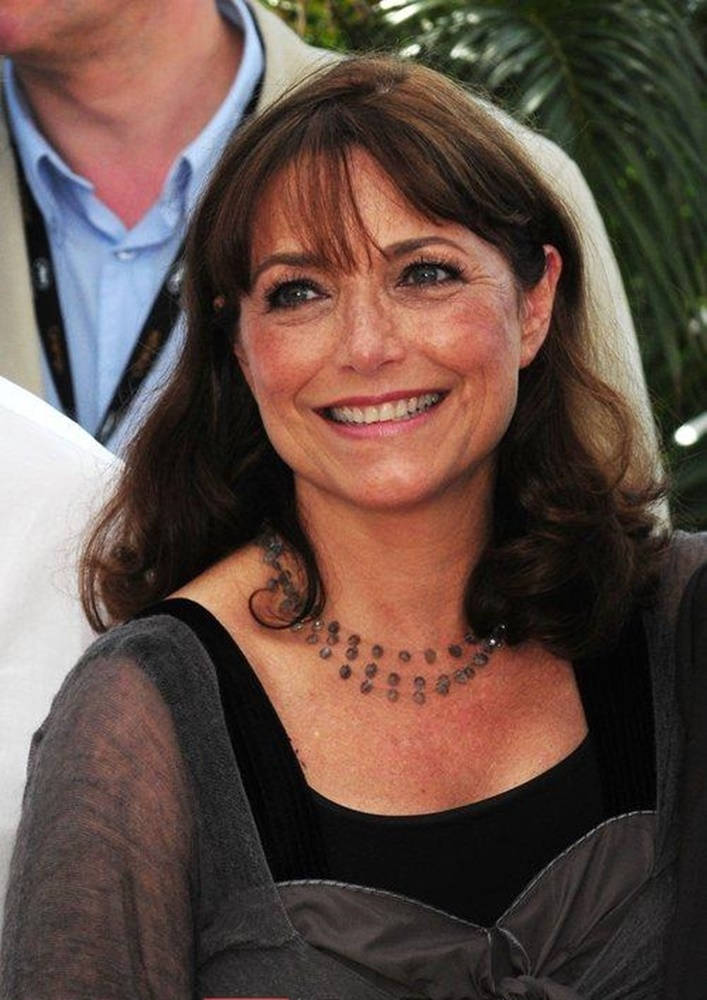 Celebrity 桌布 壁紙 — 一位微笑的棕髮女性，戴著刺青項鍊，穿著黑色上衣和透明灰色開襟衫，在戶外活動中。