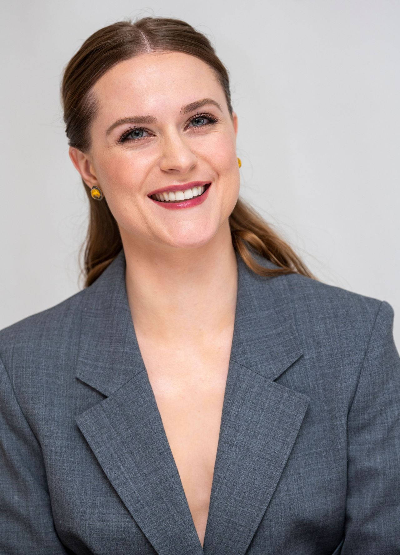 Celebrity 桌布 壁紙 — 一位微笑的棕髮女性，身穿灰色西裝外套，背景為純白色。
