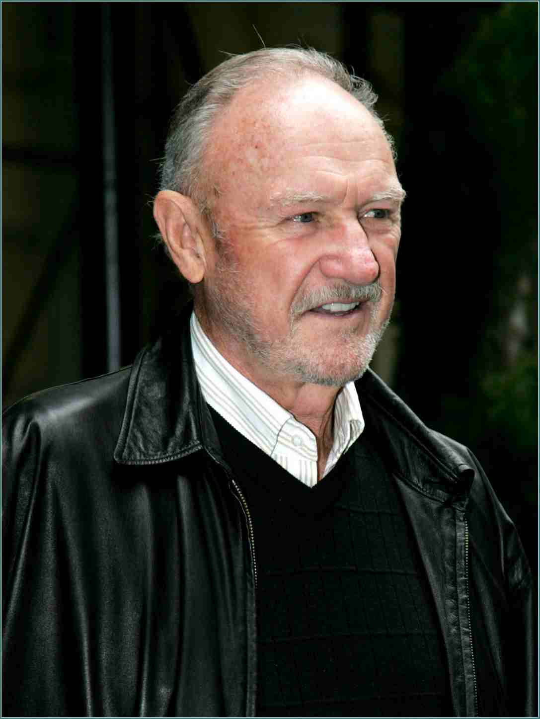 Gene Hackman 桌布 壁紙 — 一位微笑的灰髮灰鬍鬚老年男士的近距離肖像，身穿黑色皮夾克內搭條紋襯衫。
