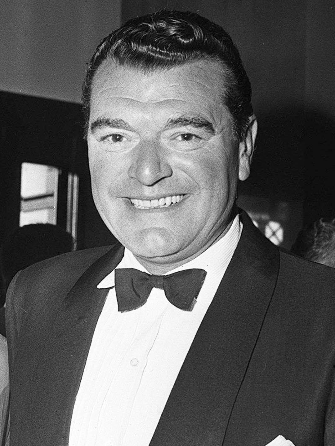 actor 桌布 壁紙 — 一位微笑的男士穿著燕尾服和蝴蝶結，在黑白照片中自信地擺姿勢。