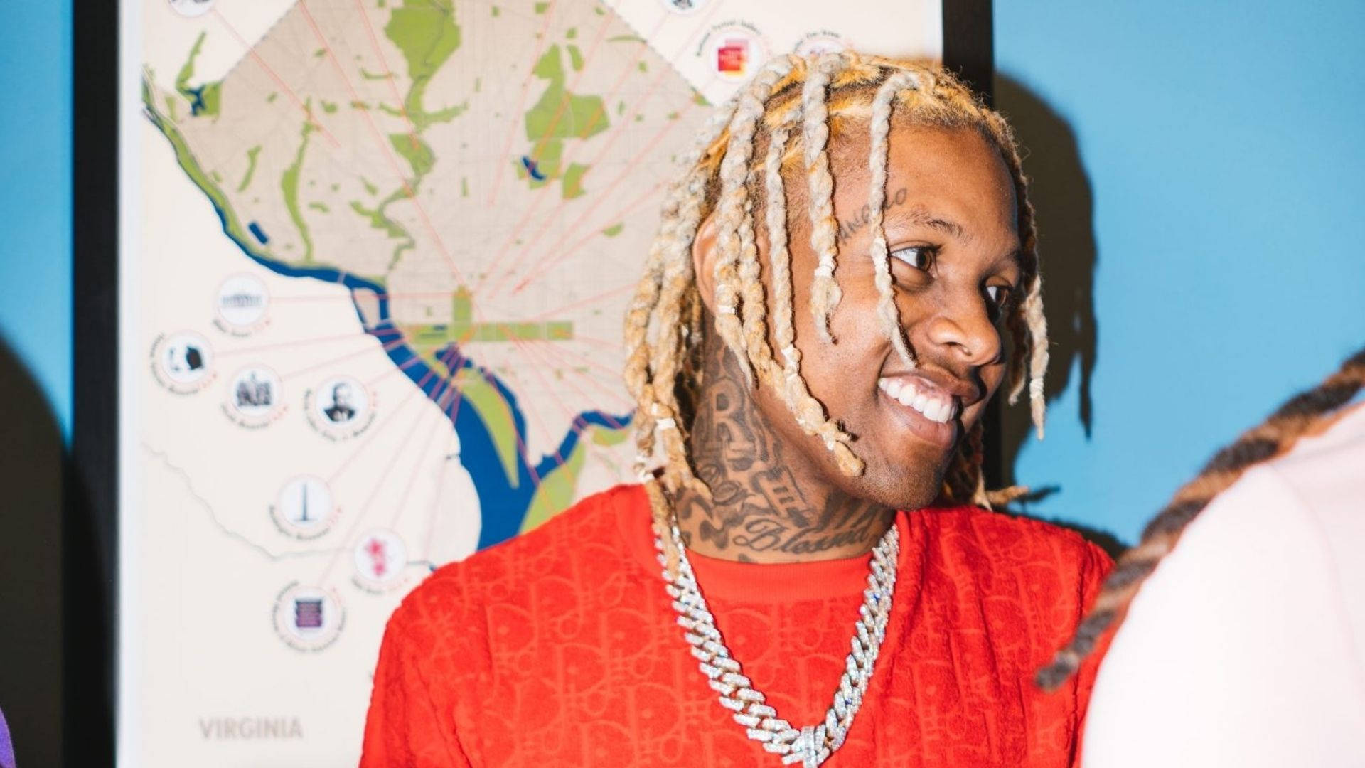 Lil Durk 桌布 壁紙 — 一位微笑的男子，編著辮子頭髮，有刺青，穿著紅色襯衫和鏈條，背景是維吉尼亞州地圖。