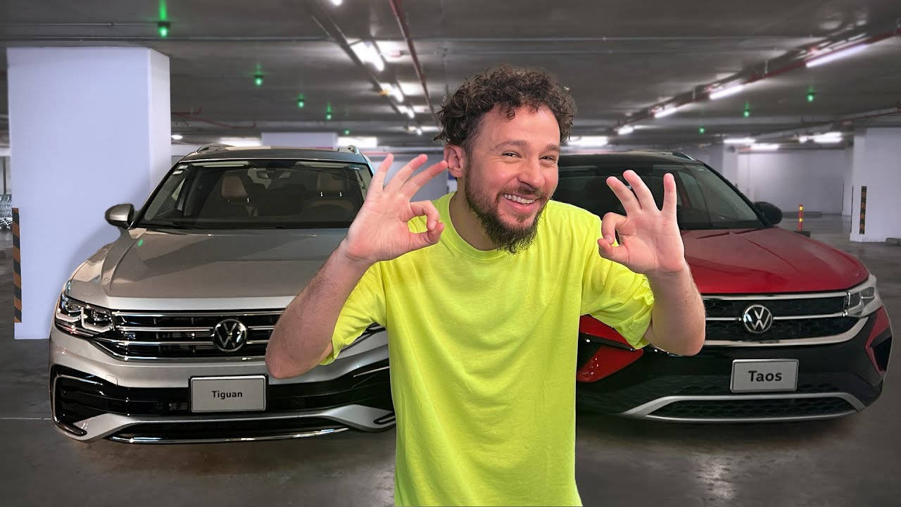 福斯汽車 桌布 壁紙 — 一位微笑的男子穿著亮黃色襯衫，在光線充足的地下停車場中，於兩輛Volkswagen SUV前做出OK手勢。