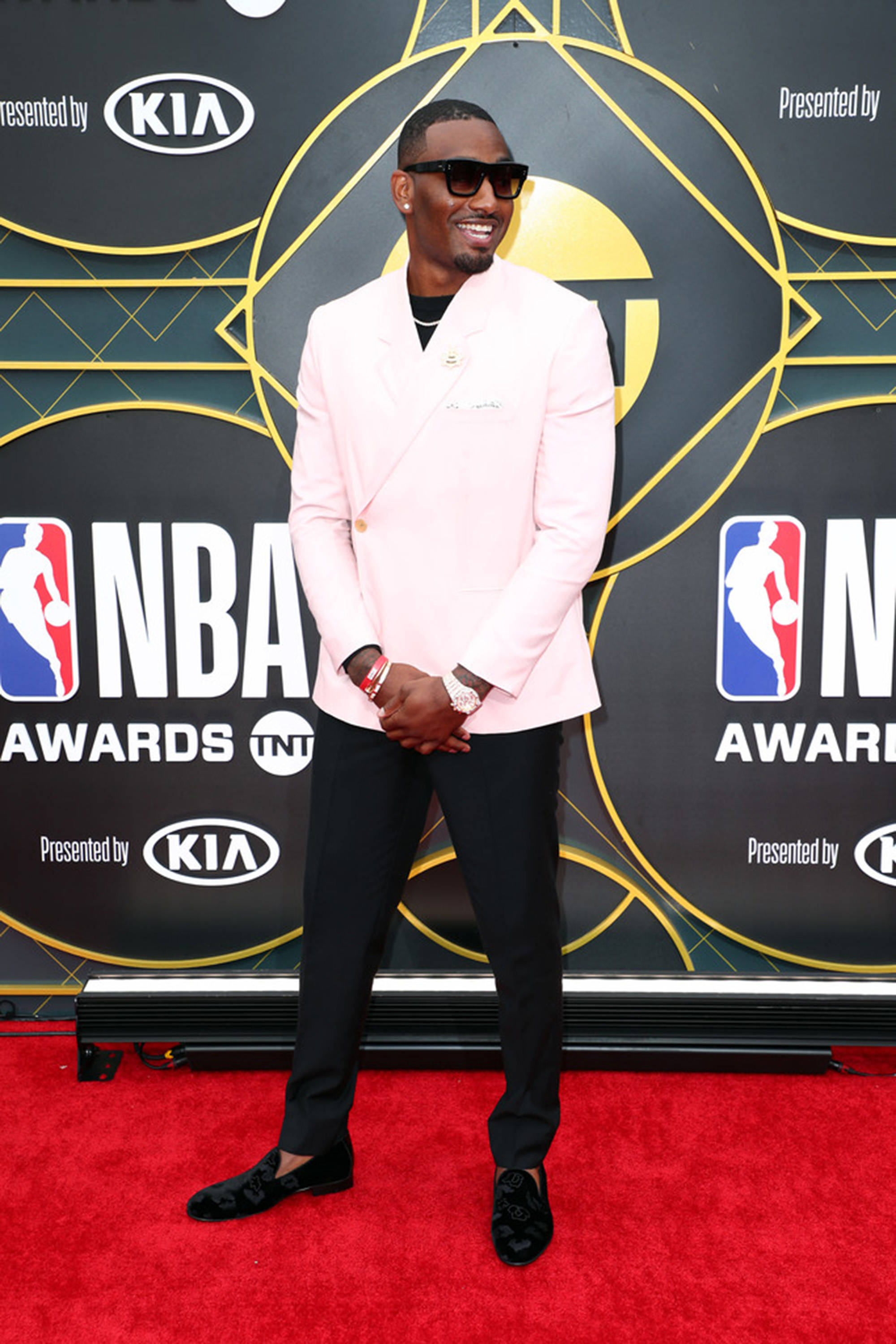John Wall 桌布 壁紙 — 一位微笑的男子身穿粉紅色西裝外套和黑色褲子，在NBA頒獎典禮的紅地毯上自信地擺姿勢。