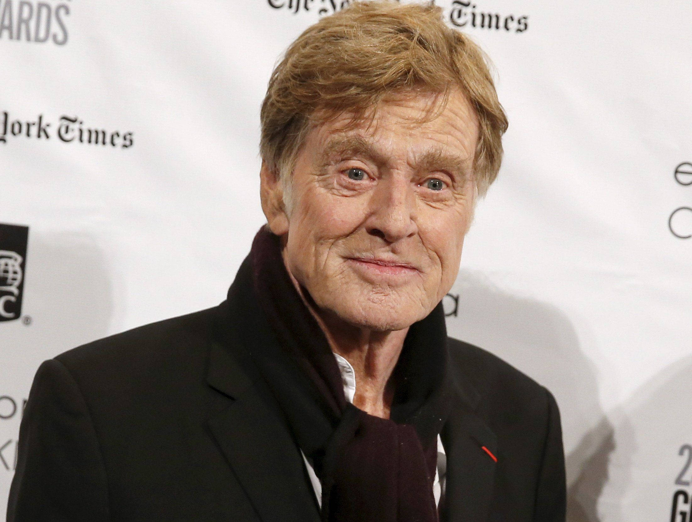 Celebrity 桌布 壁紙 — 一位微笑的白髮年長男士的特寫肖像，身穿黑色西裝和深色圍巾，背景是白色活動背景。