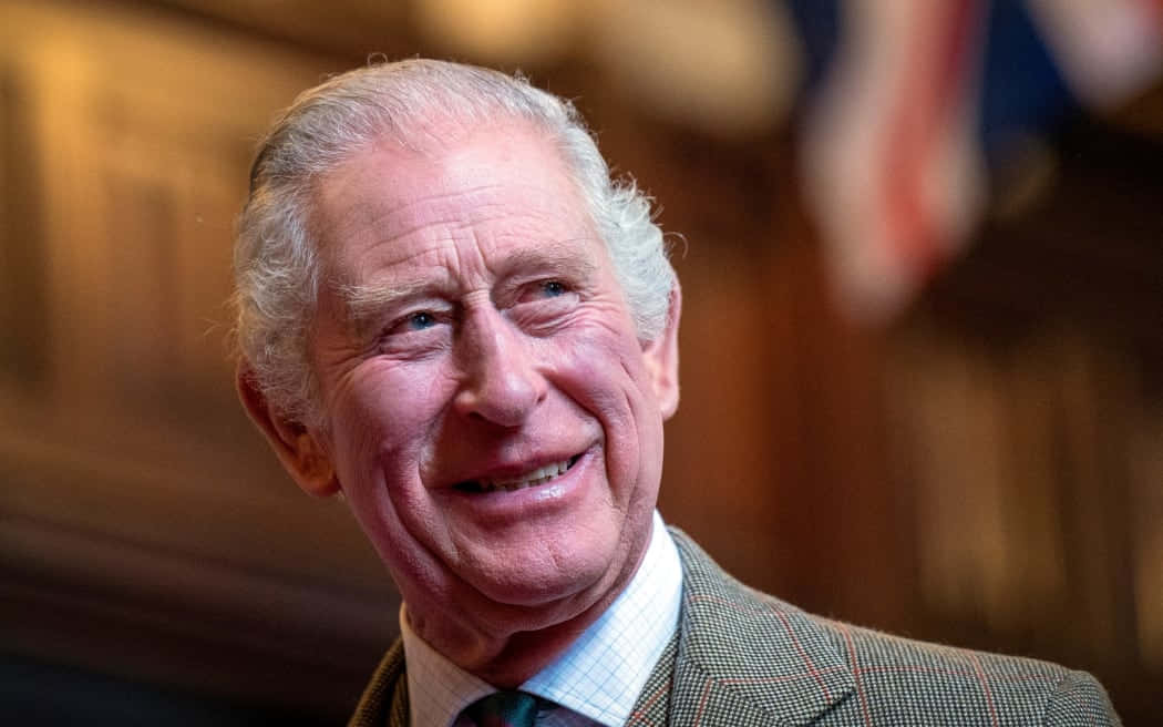 Celebrity 桌布 壁紙 — 一位微笑的白髮老年男子穿著粗花呢外套在室內溫暖燈光下的特寫肖像。