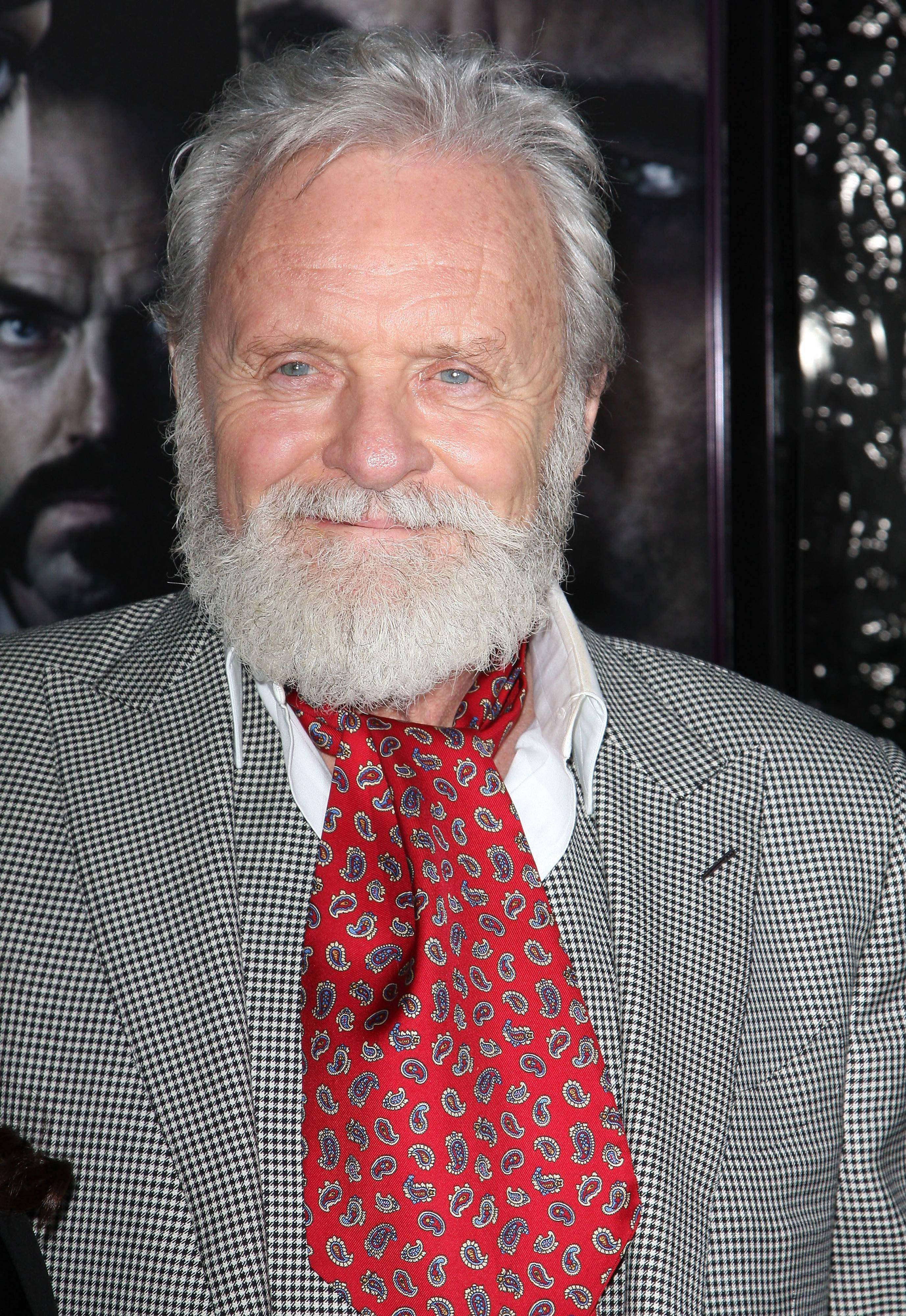 actor 桌布 壁紙 — 一位微笑的白鬍子灰髮老年男士，身穿格紋西裝和紅色佩斯利領帶。