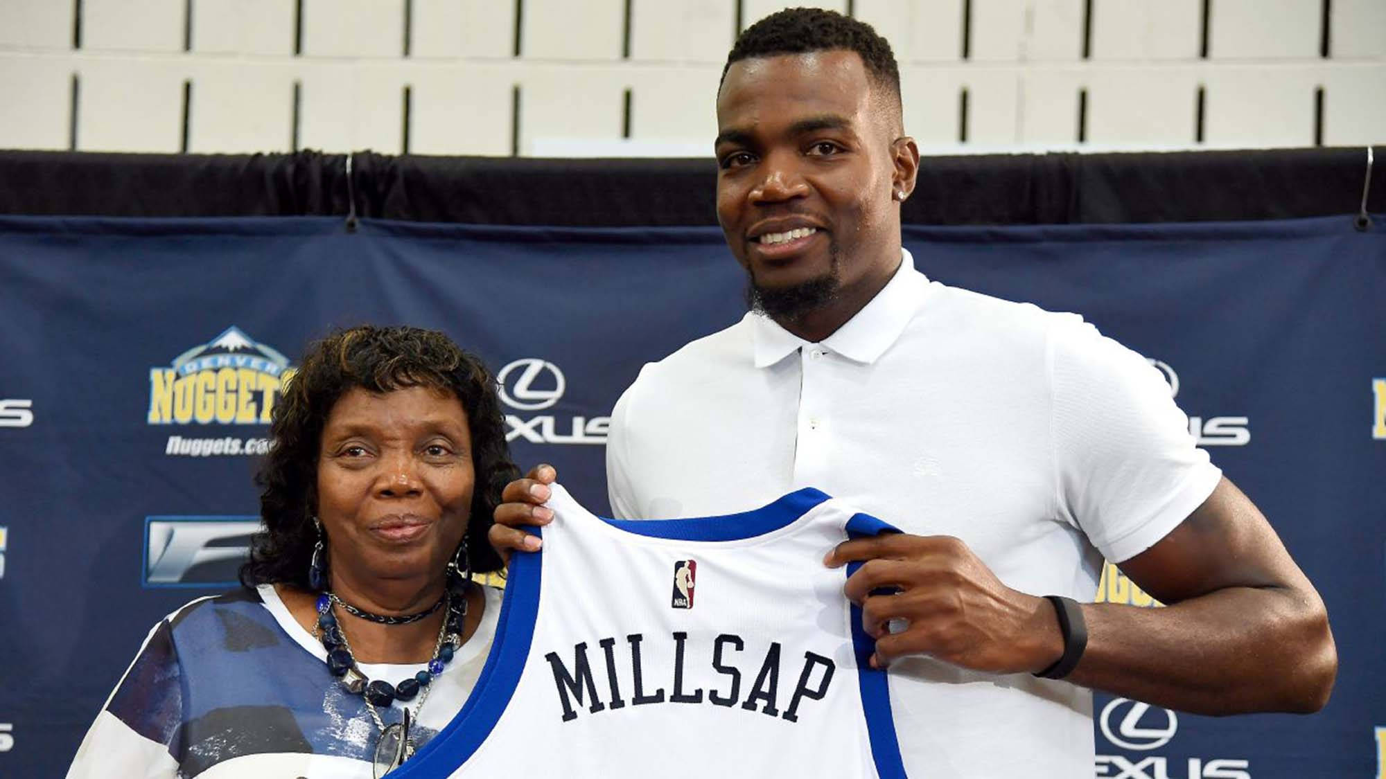paul millsap 桌布 壁紙 — 一位微笑的籃球運動員在丹佛金塊隊活動中與母親一起舉起他的球衣。