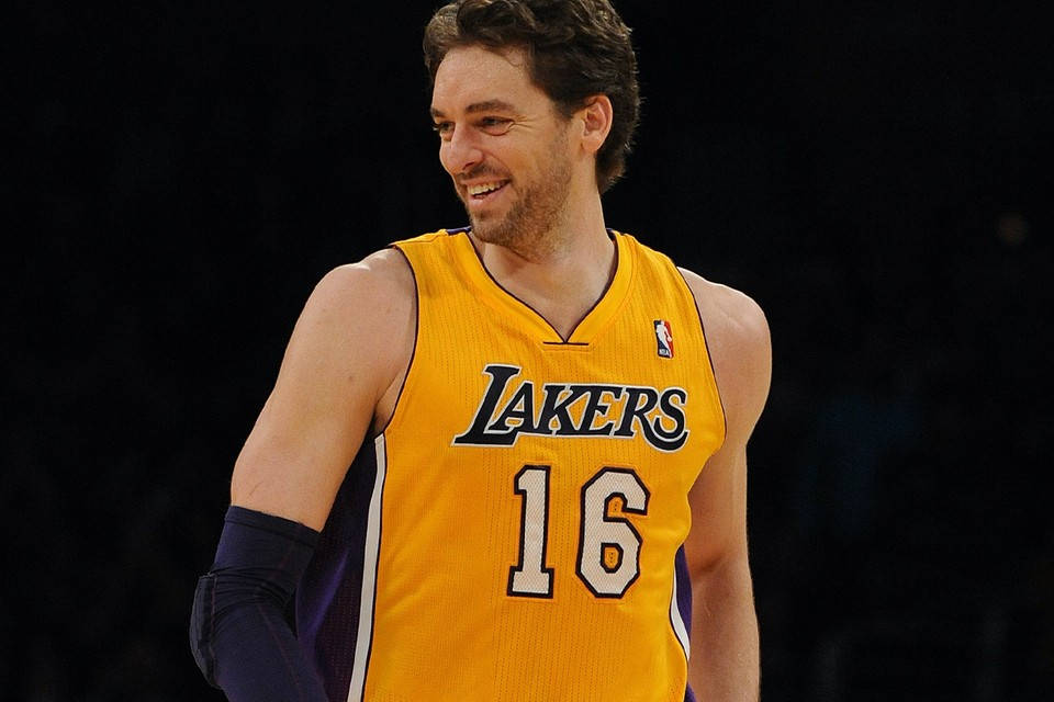 Pau Gasol 桌布 壁紙 — 一位微笑的籃球運動員身穿黃色湖人隊16號球衣，站在深色背景前。