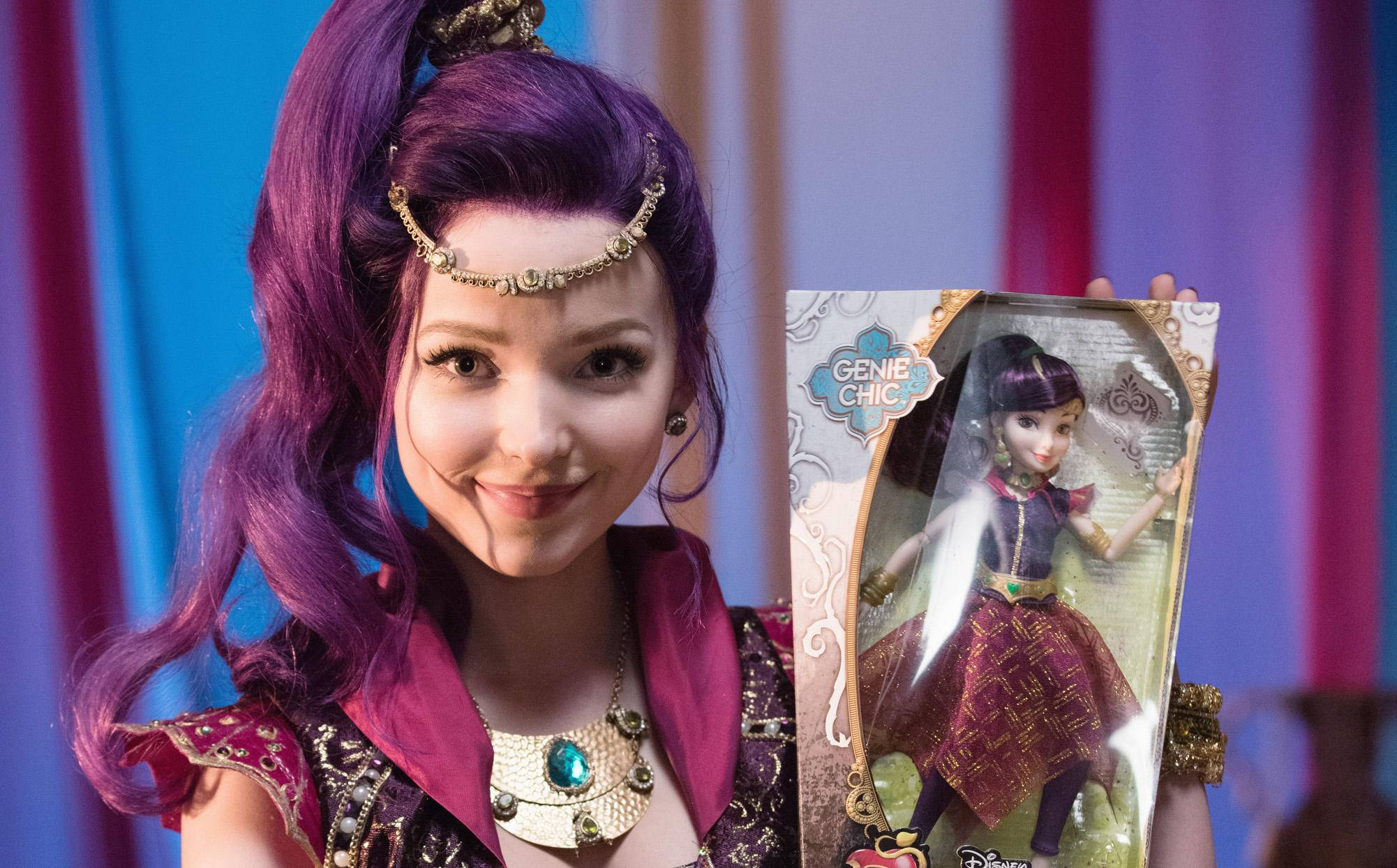 Descendants 桌布 壁紙 — 一位微笑的紫髮女性，在色彩繽紛的窗簾背景下，手持包裝中的Disney Genie Chic公仔。