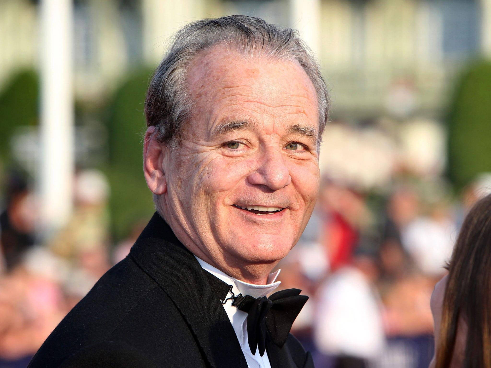 Celebrity 桌布 壁紙 — 一位微笑的老年男士穿著黑色燕尾服和領結，在一個正式的戶外活動中擺姿勢，身後有模糊的人群。