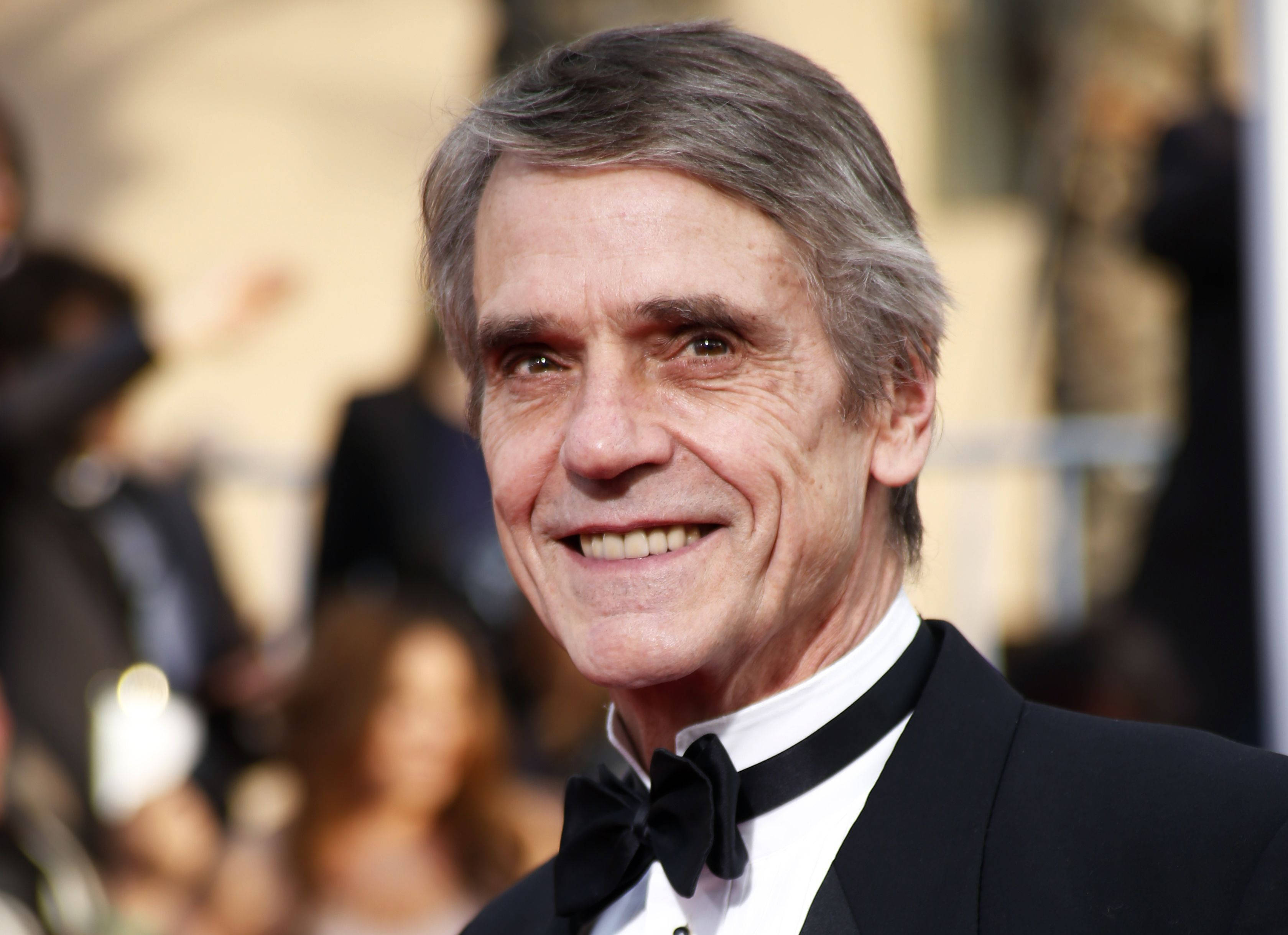 Celebrity 桌布 壁紙 — 一位微笑的老年男士穿著黑色燕尾服和領結在華麗活動中的特寫肖像。