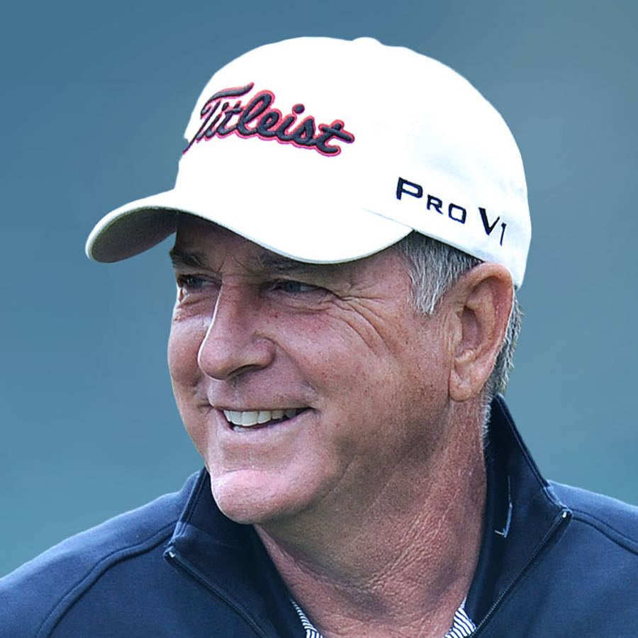 Smile 桌布 壁紙 — 一位微笑的老年男子，戴著白色Titleist Pro V1帽子，穿著深色外套，背景為柔和的藍色。