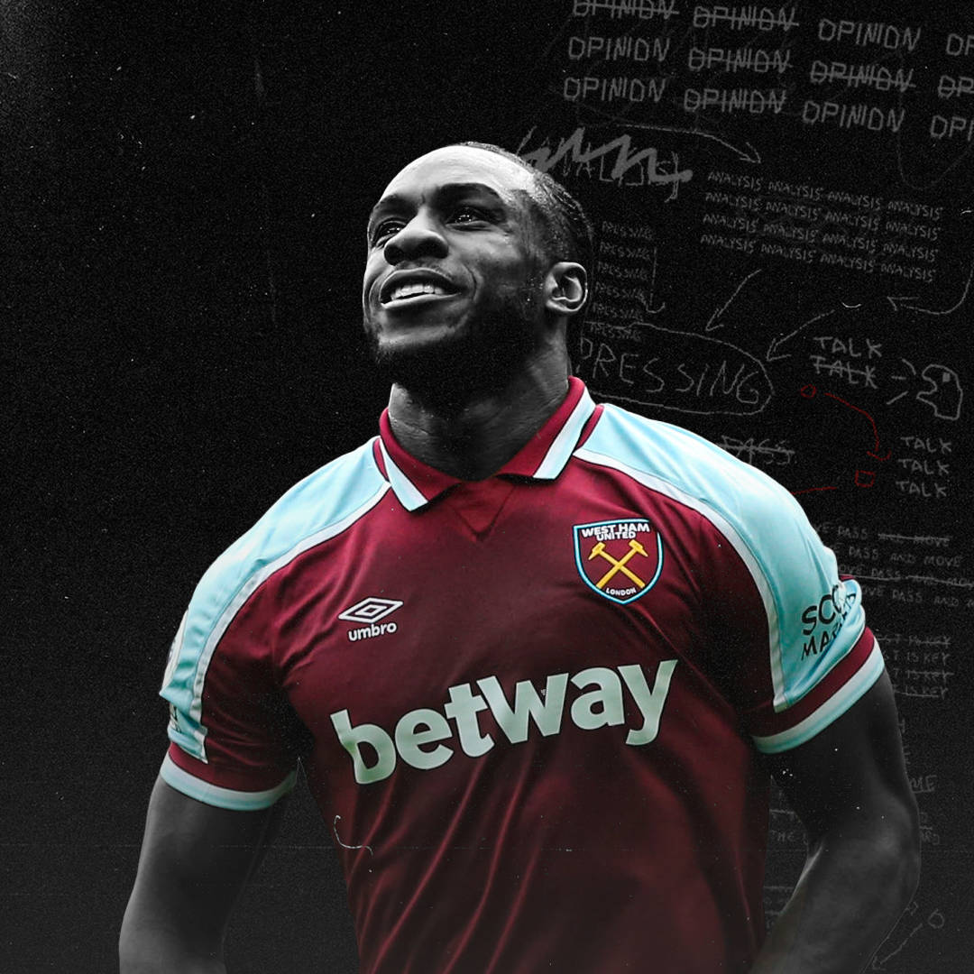 West Ham United Fc 桌布 壁紙 — 一位微笑的西漢姆聯足球員，身穿棗紅色和淺藍色球衣，站在一個充滿戰術筆記的深色黑板前。