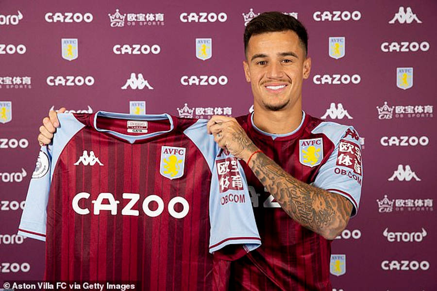 Philippe Coutinho 桌布 壁紙 — 一位微笑的足球員在品牌紫色背景前自豪地展示他的阿斯頓維拉球衣。