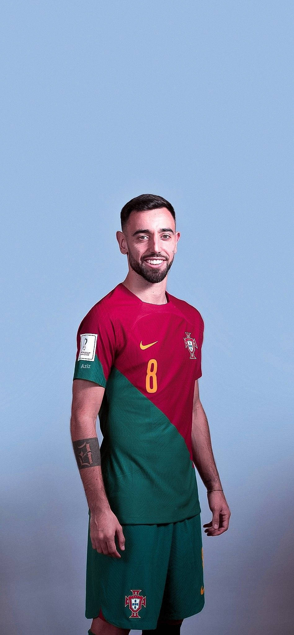 Portugal 桌布 壁紙 — 一位微笑的足球員身穿葡萄牙紅綠色球衣，號碼8，自信地站在純藍色攝影棚背景前。