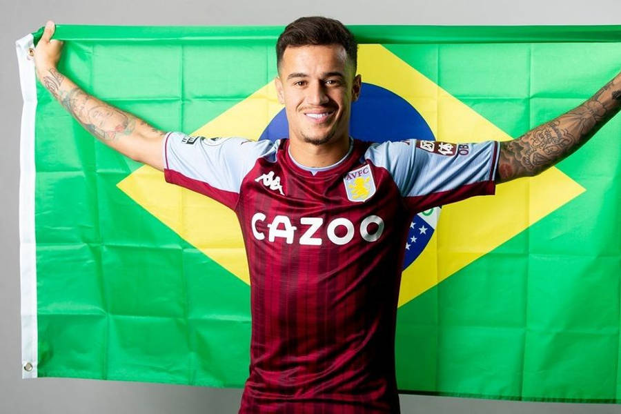 Philippe Coutinho 桌布 壁紙 — 一位微笑的足球員身穿酒紅色條紋球衣，自豪地高舉刺青手臂，身後拿著巴西國旗。