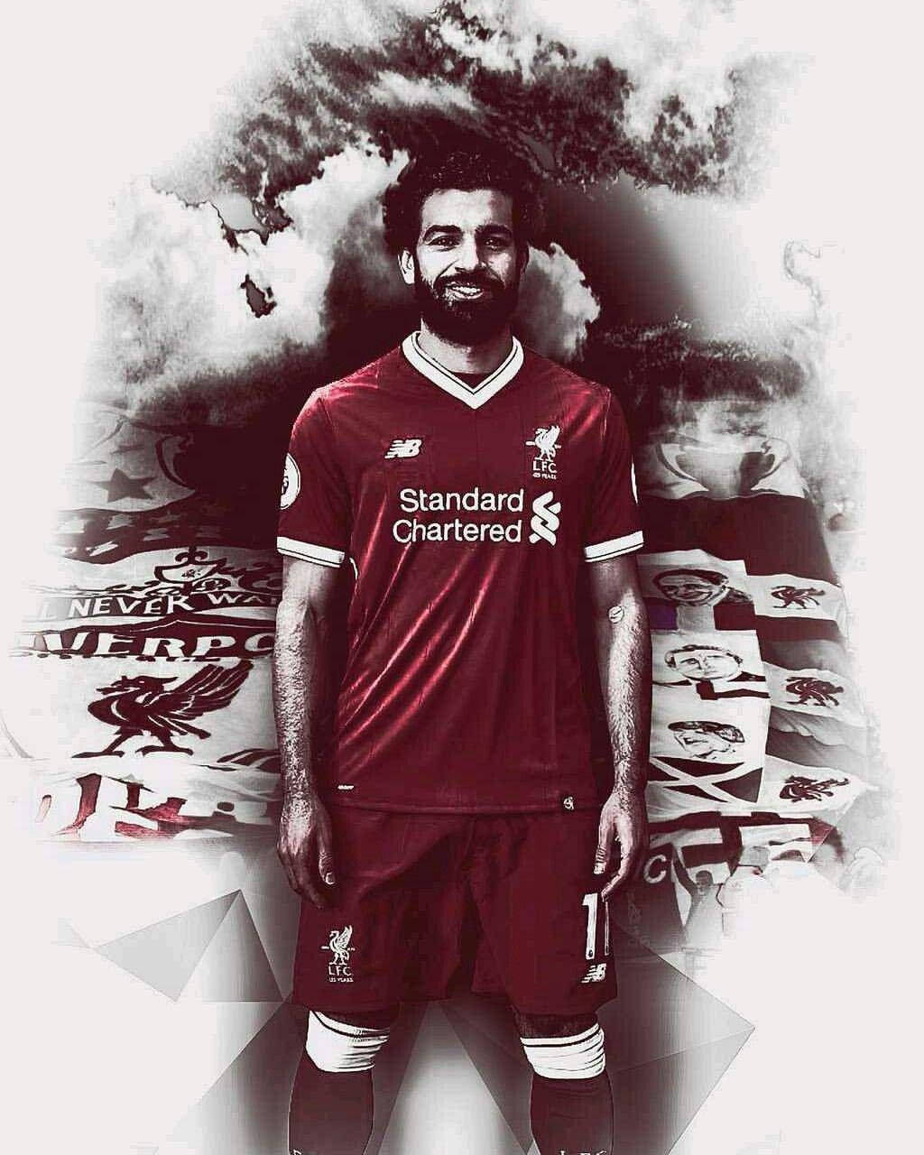 Salah 桌布 壁紙 — 一位微笑的足球運動員身穿紅色利物浦球衣，站在俱樂部標誌和煙霧效果的風格化背景前。