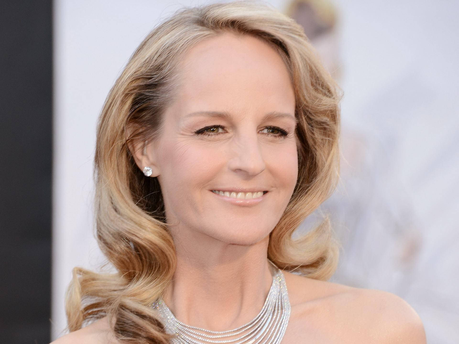 Celebrity 桌布 壁紙 — 一位微笑的金色波浪長髮女士的特寫肖像，戴著閃閃發光的銀色項鍊和鑽石耳環。