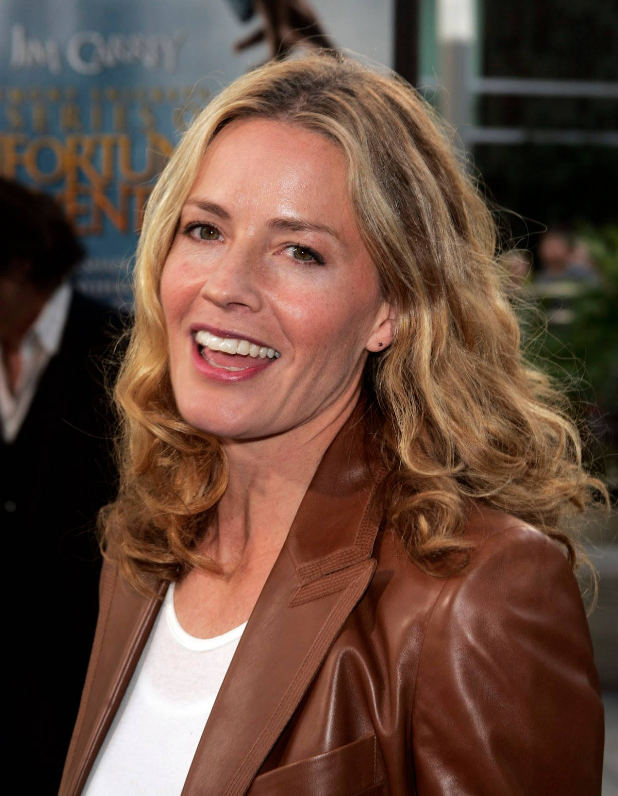 Celebrity 桌布 壁紙 — 一位微笑的金色波浪長髮女性在電影首映活動中穿著棕色皮夾克。