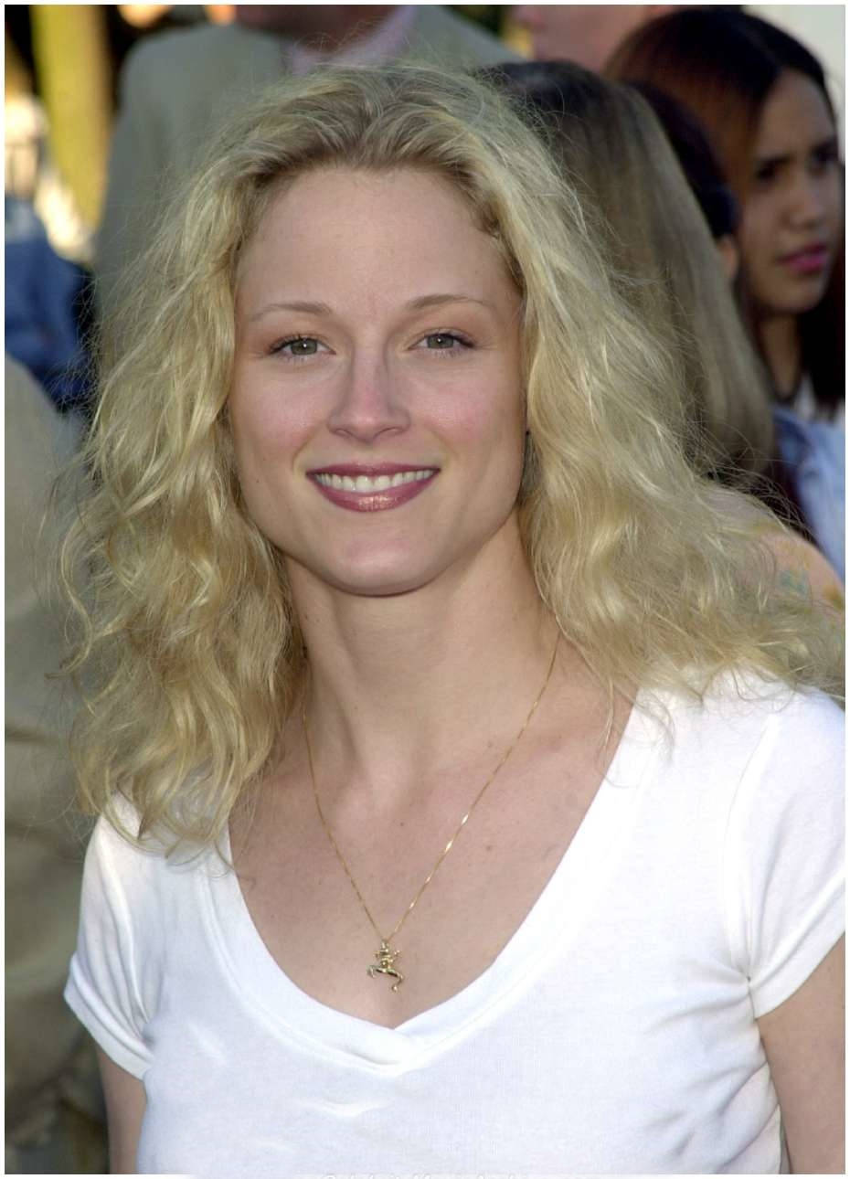 Celebrity 桌布 壁紙 — 一位微笑的金髮女子，波浪長髮，身穿白色V領T恤，佩戴精緻的金項鍊。
