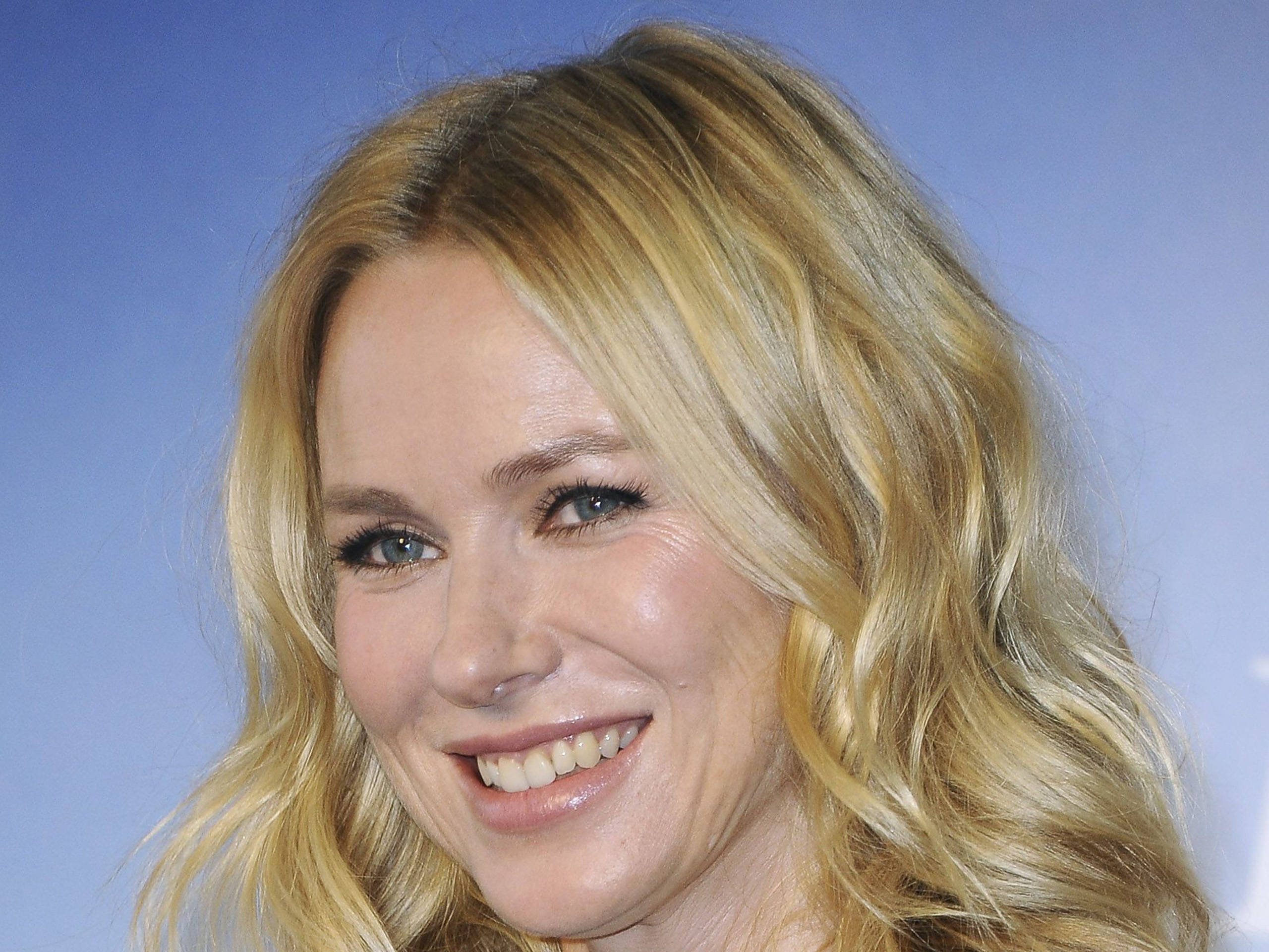 Celebrity 桌布 壁紙 — 一位微笑的金髮女子，波浪頭髮，在純藍色背景下的特寫肖像。