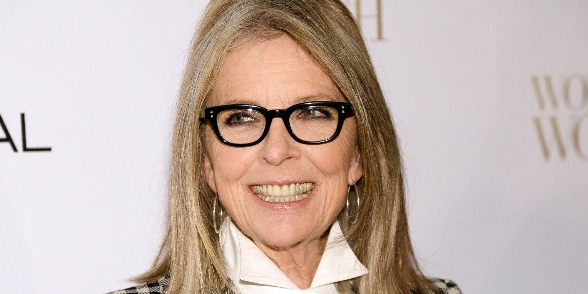 oscars 桌布 壁紙 — 一位微笑的金髮女子戴著黑色眼鏡，穿著白色領子和圖案外套出席正式活動。