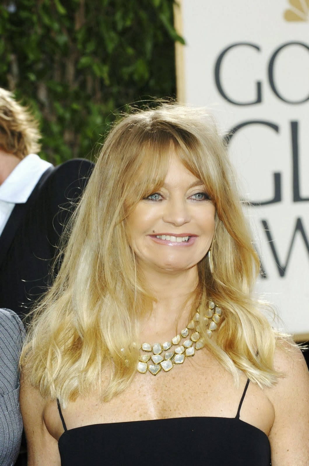 Celebrity 桌布 壁紙 — 一位微笑的金髮女性，身穿黑色連衣裙和金色項鍊，出席金球獎頒獎典禮。