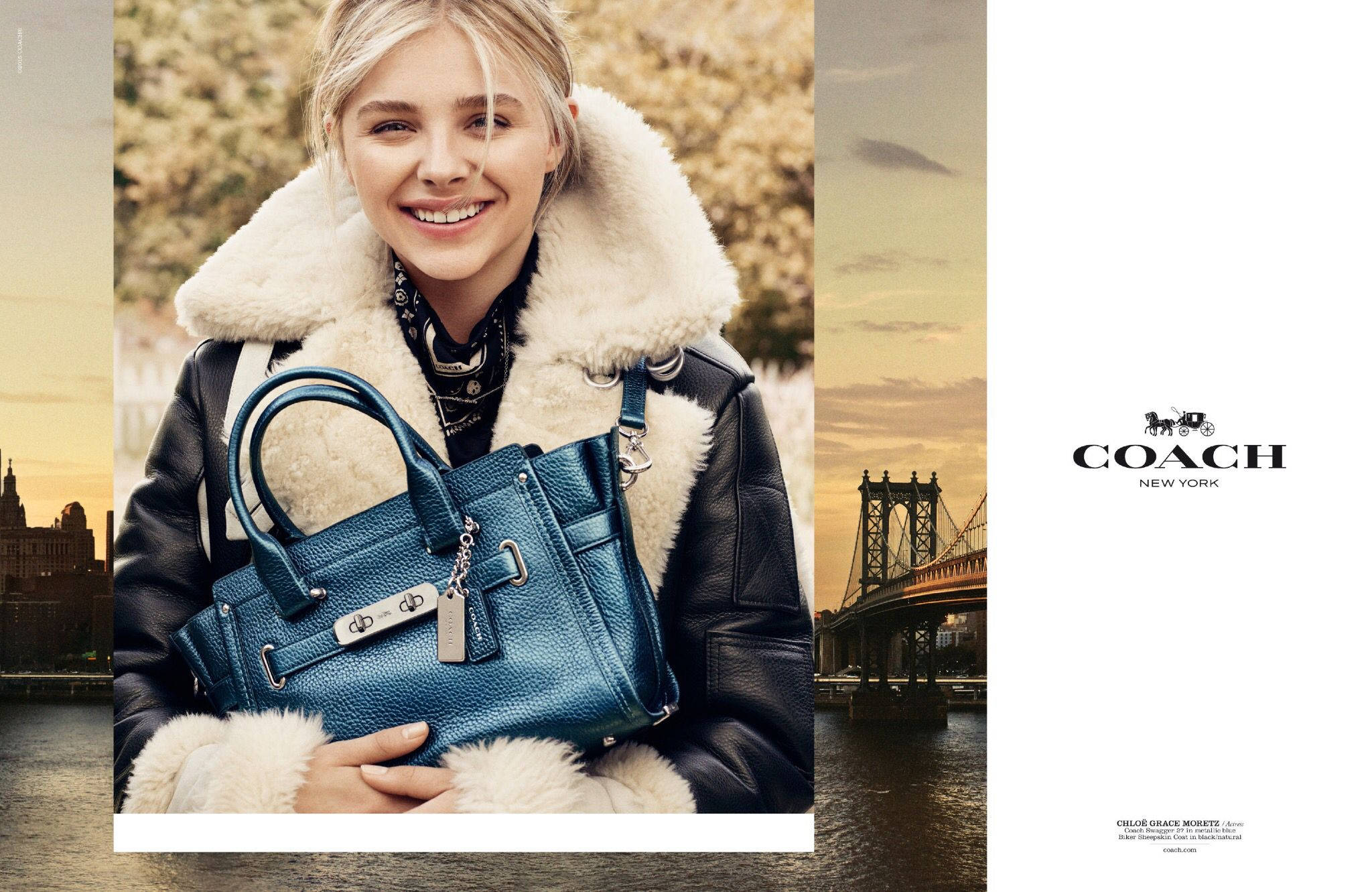 Coach 桌布 壁紙 — 一位微笑的金髮女性穿著毛領皮夾克，手持藍色Coach手袋，背景是帶有橋樑的金色城市天際線。