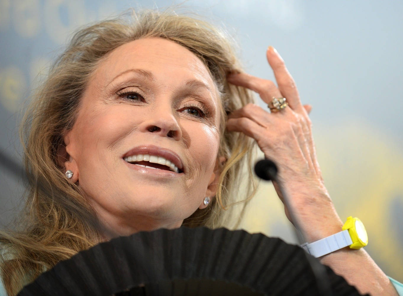 Celebrity 桌布 壁紙 — 一位微笑的金髮女性輕輕觸摸她的頭髮，戴著黃色手錶和珍珠耳環。