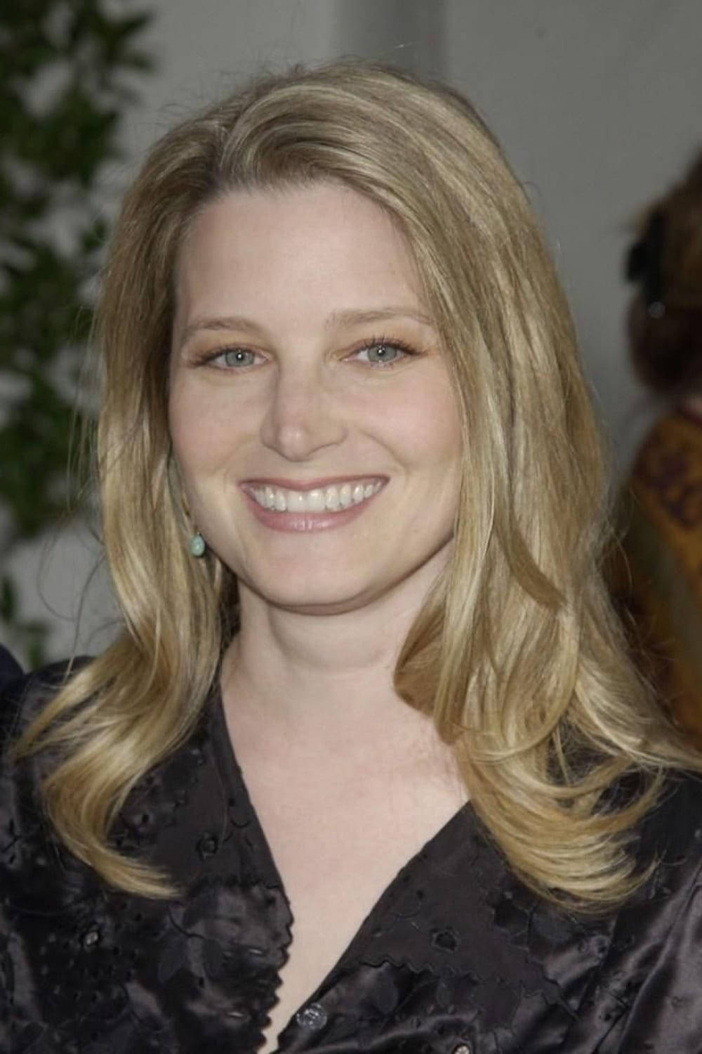 Celebrity 桌布 壁紙 — 一位微笑的金髮藍眼女性，穿著黑色圖案襯衫，背景是柔和模糊的室內環境。