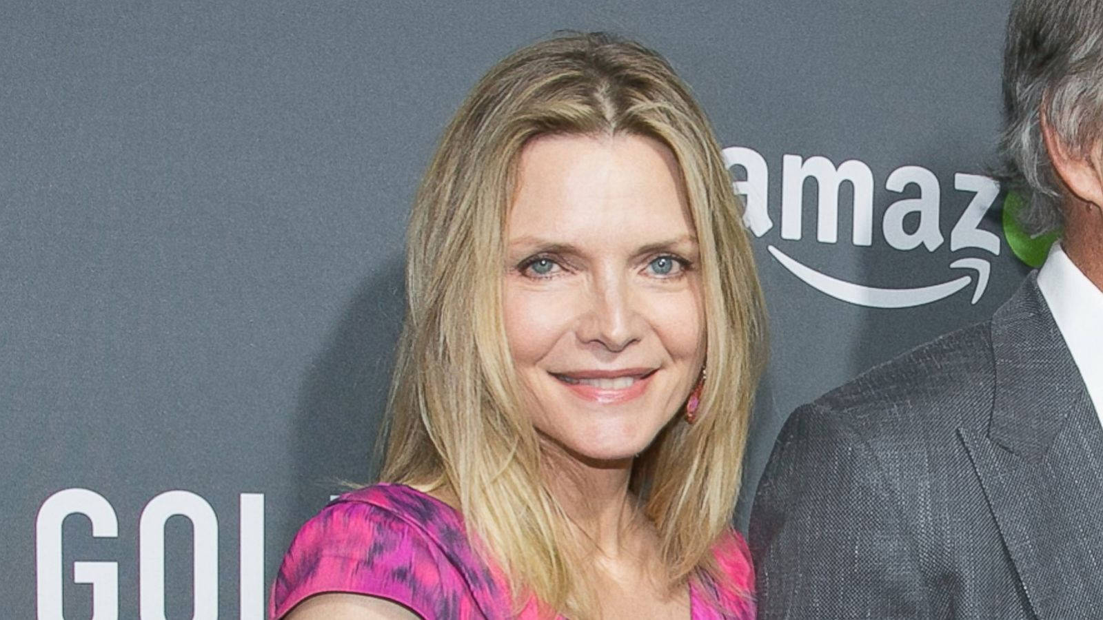 Celebrity 桌布 壁紙 — 一位微笑的金髮藍眼女性在亞馬遜活動中穿著鮮豔的粉紅色圖案上衣。