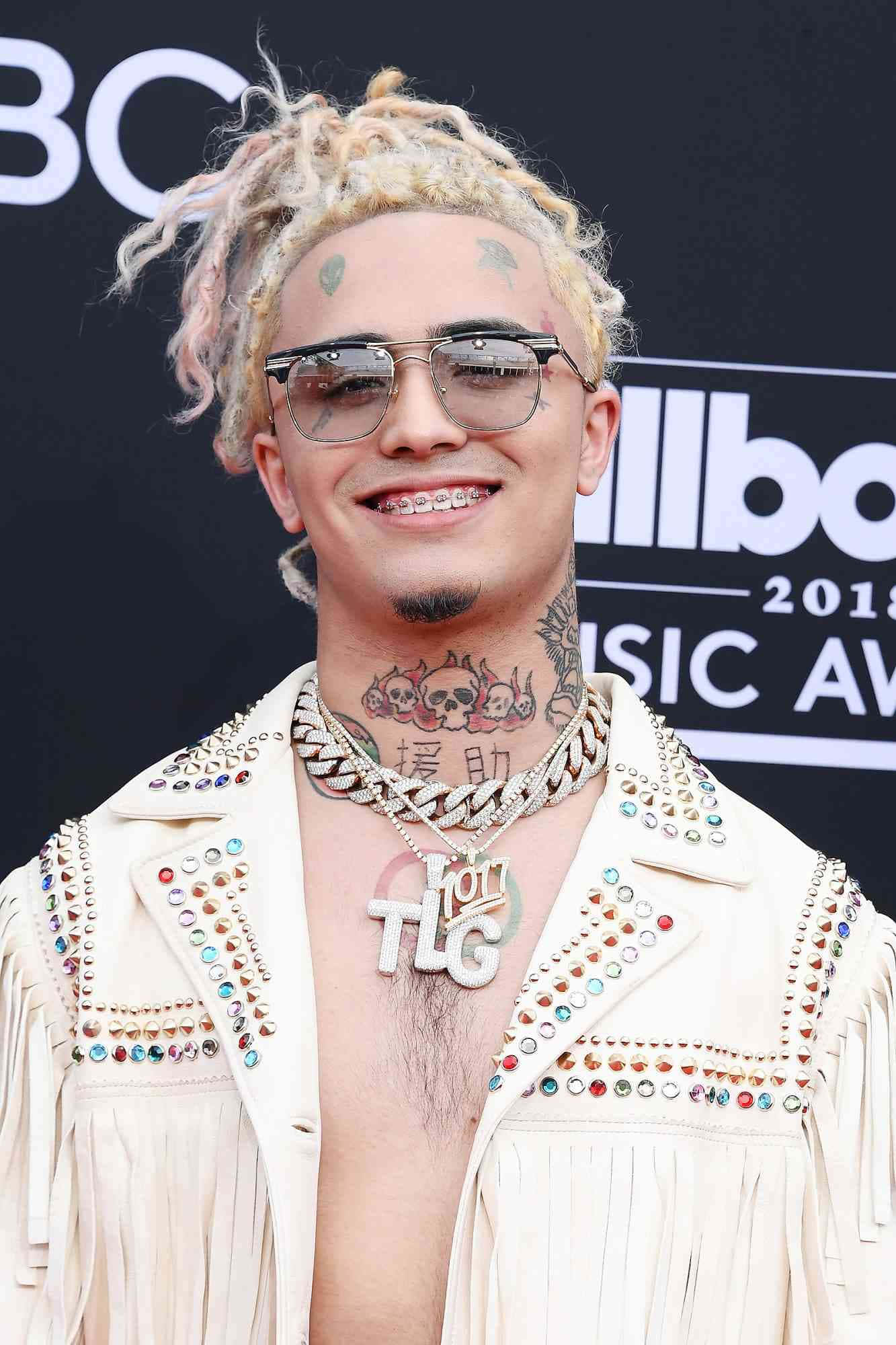 桌布 壁紙 — 一位微笑的金髮辮子刺青男子，在2018年Billboard音樂獎上穿著飾有鉚釘的奶油色外套。