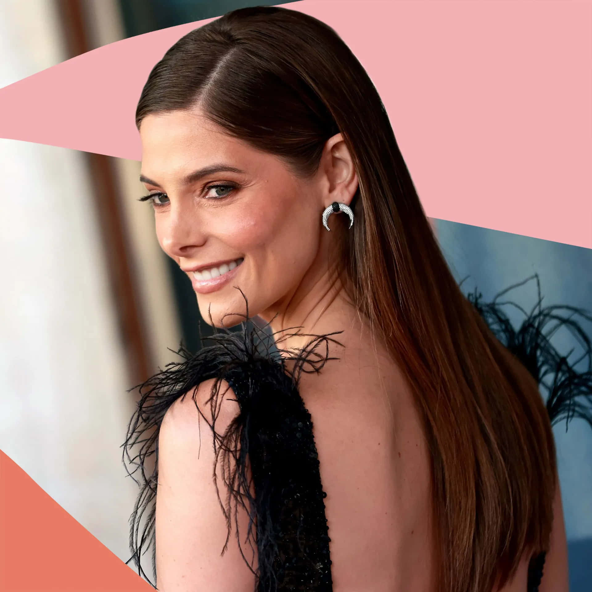 ashley greene 桌布 壁紙 — 一位微笑的長棕髮女性，身穿黑色羽毛連衣裙，戴著新月形耳環，背景是粉紅色和珊瑚色的幾何圖案。