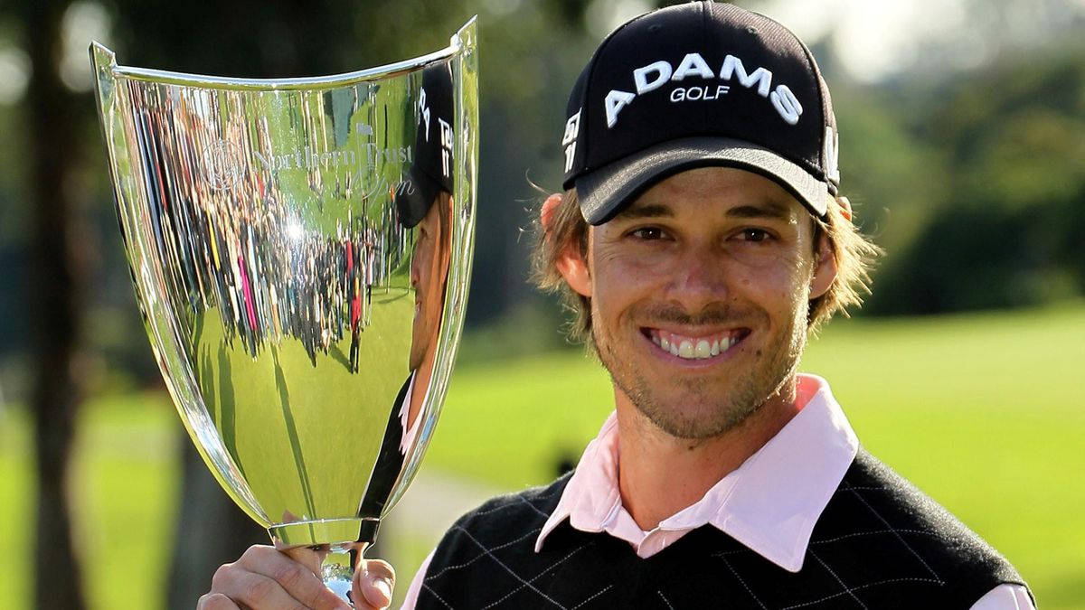 Champion 桌布 壁紙 — 一位微笑的高爾夫球手在陽光明媚的高爾夫球場上自豪地舉起閃亮的獎盃，背景是茂密的綠草和樹木。