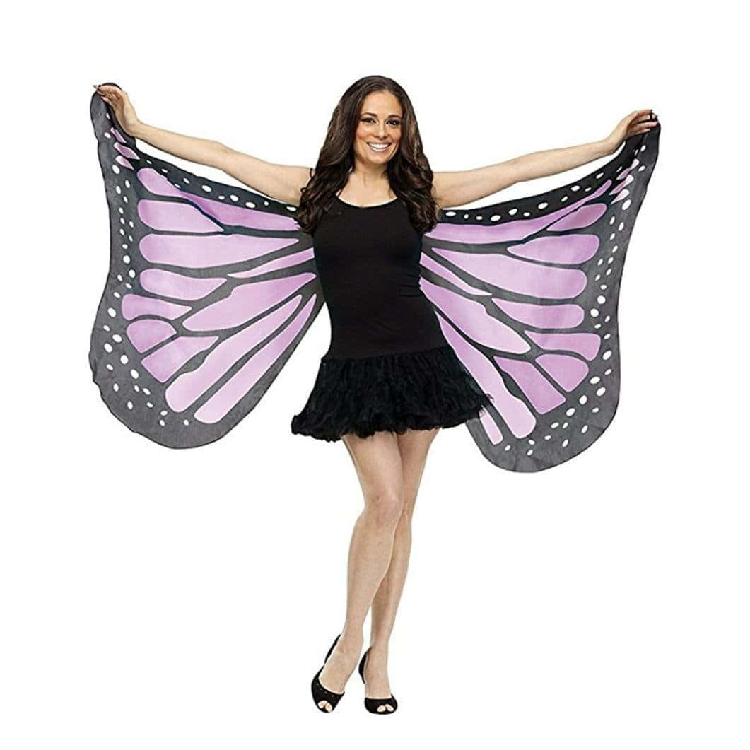 Butterfly Wing Dress 桌布 壁紙 — 一位微笑的黑裙女士在白色背景前舉起大片的紫色和灰色蝴蝶翅膀。