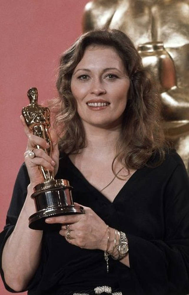 Celebrity 桌布 壁紙 — 一位微笑的黑裙女士手持金色奧斯卡獎座，背景為粉紅色，身後有一個更大的雕像。