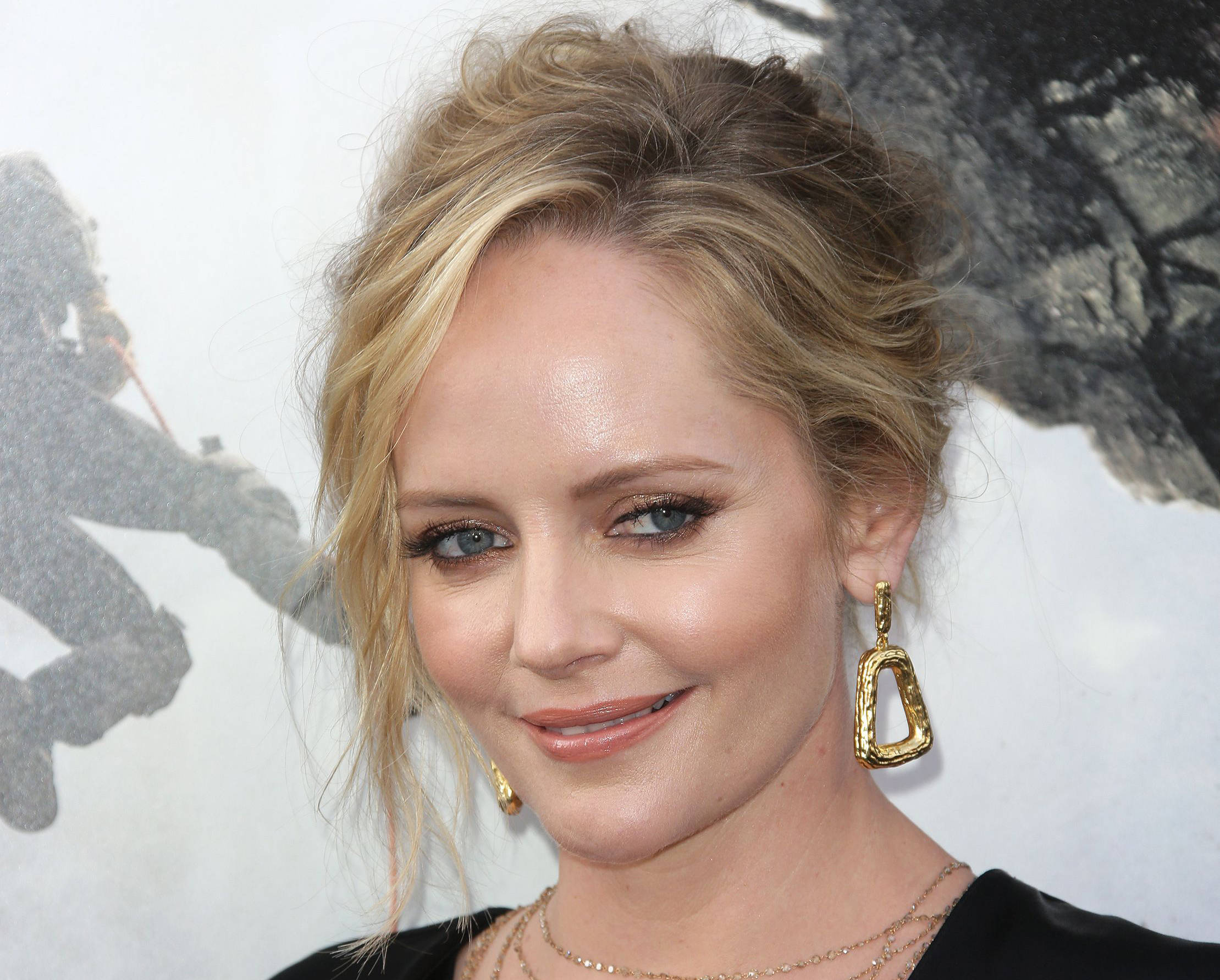 Celebrity 桌布 壁紙 — 一位微笑金髮藍眼女性佩戴金色耳環和黑色上衣的特寫肖像。