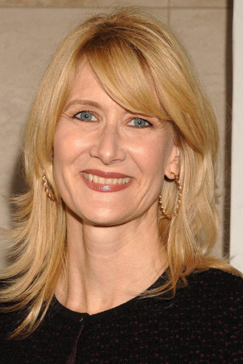Celebrity 桌布 壁紙 — 一位微笑金髮藍眼女性戴著金色圓環耳環和黑色上衣的特寫肖像。