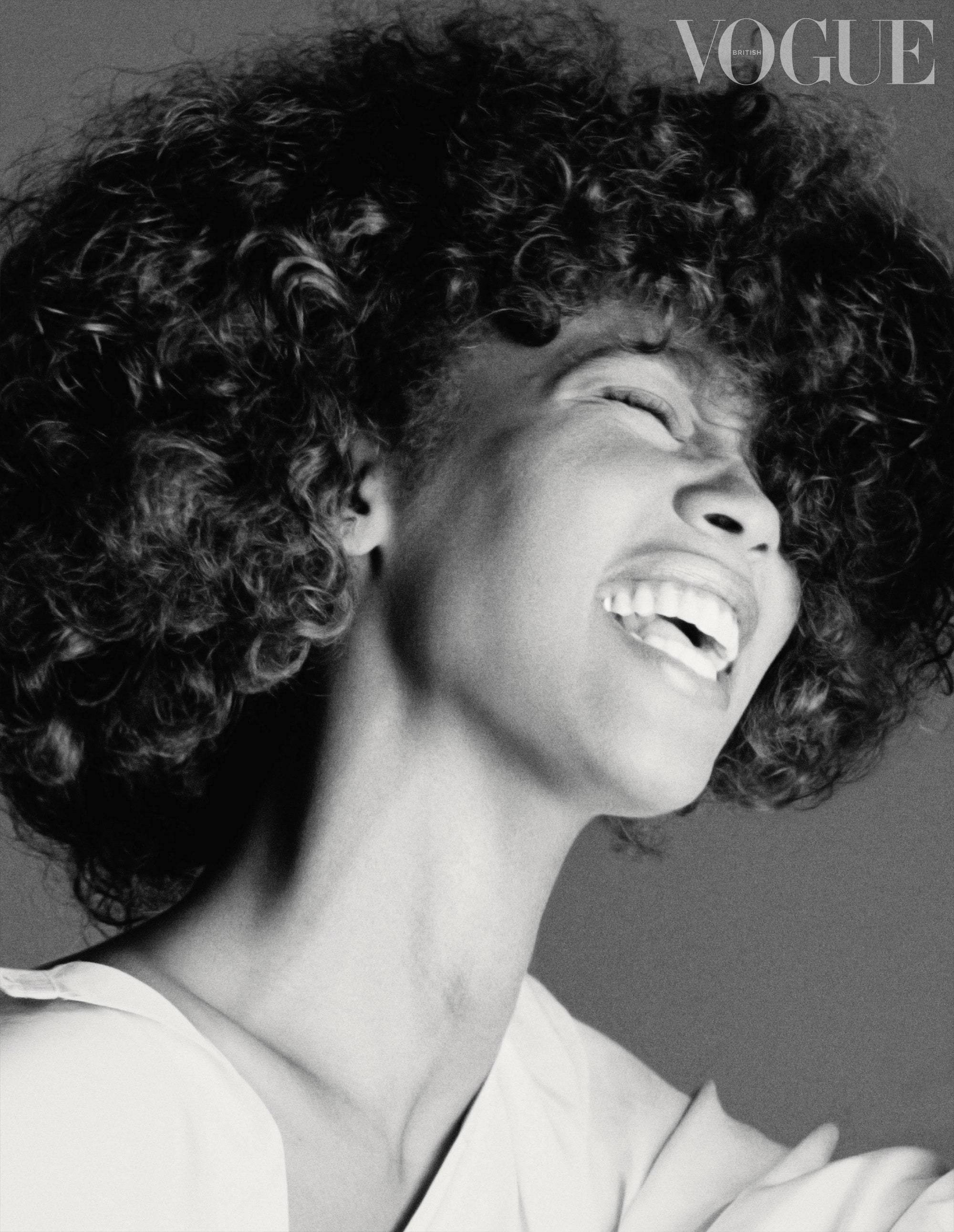 Whitney 桌布 壁紙 — 一位快樂的女士，擁有豐盈的捲髮，在引人注目的黑白Vogue肖像中開懷大笑。