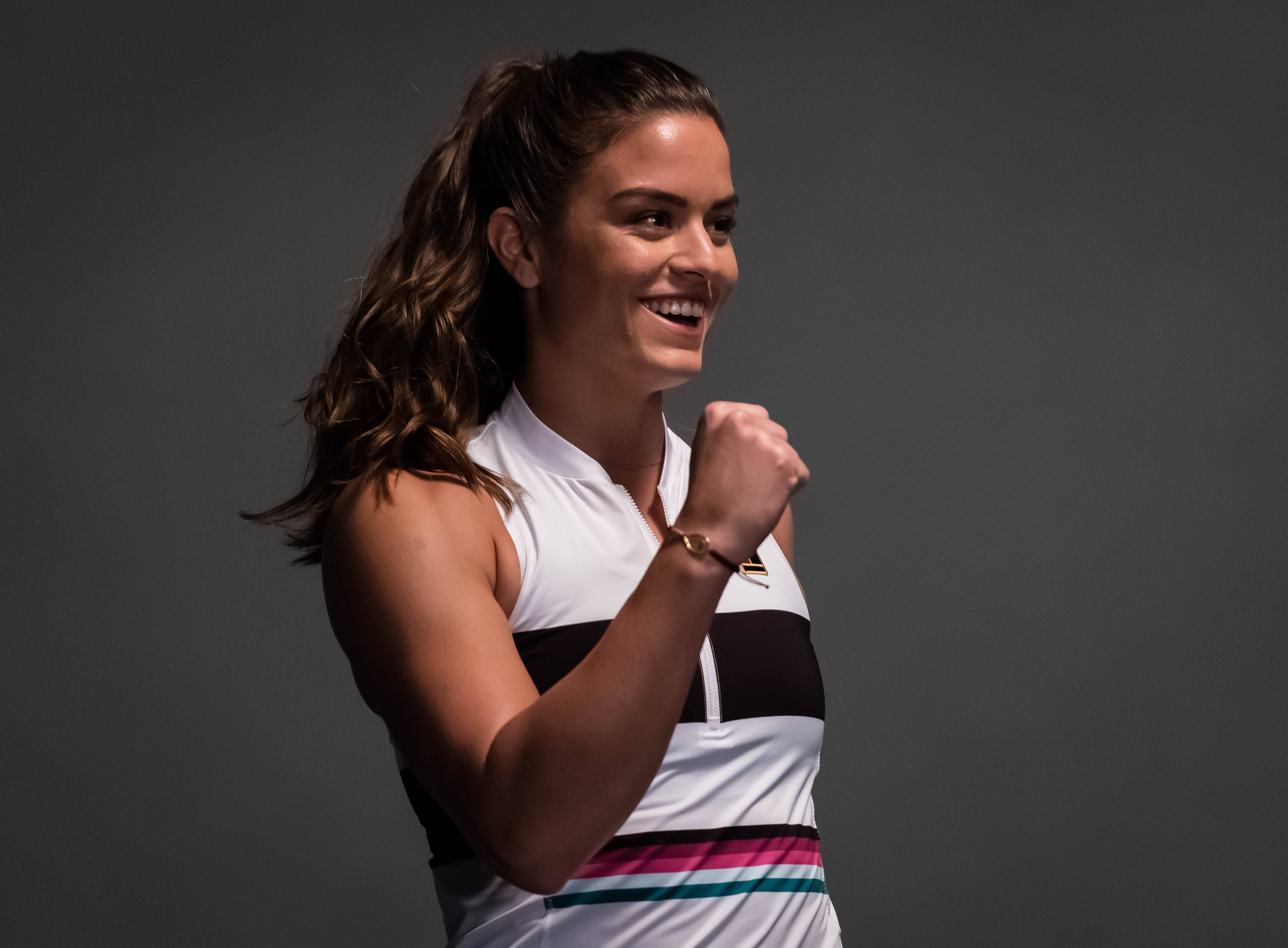 Tennis 桌布 壁紙 — 一位快樂的女網球運動員在純灰色工作室背景前握拳慶祝。