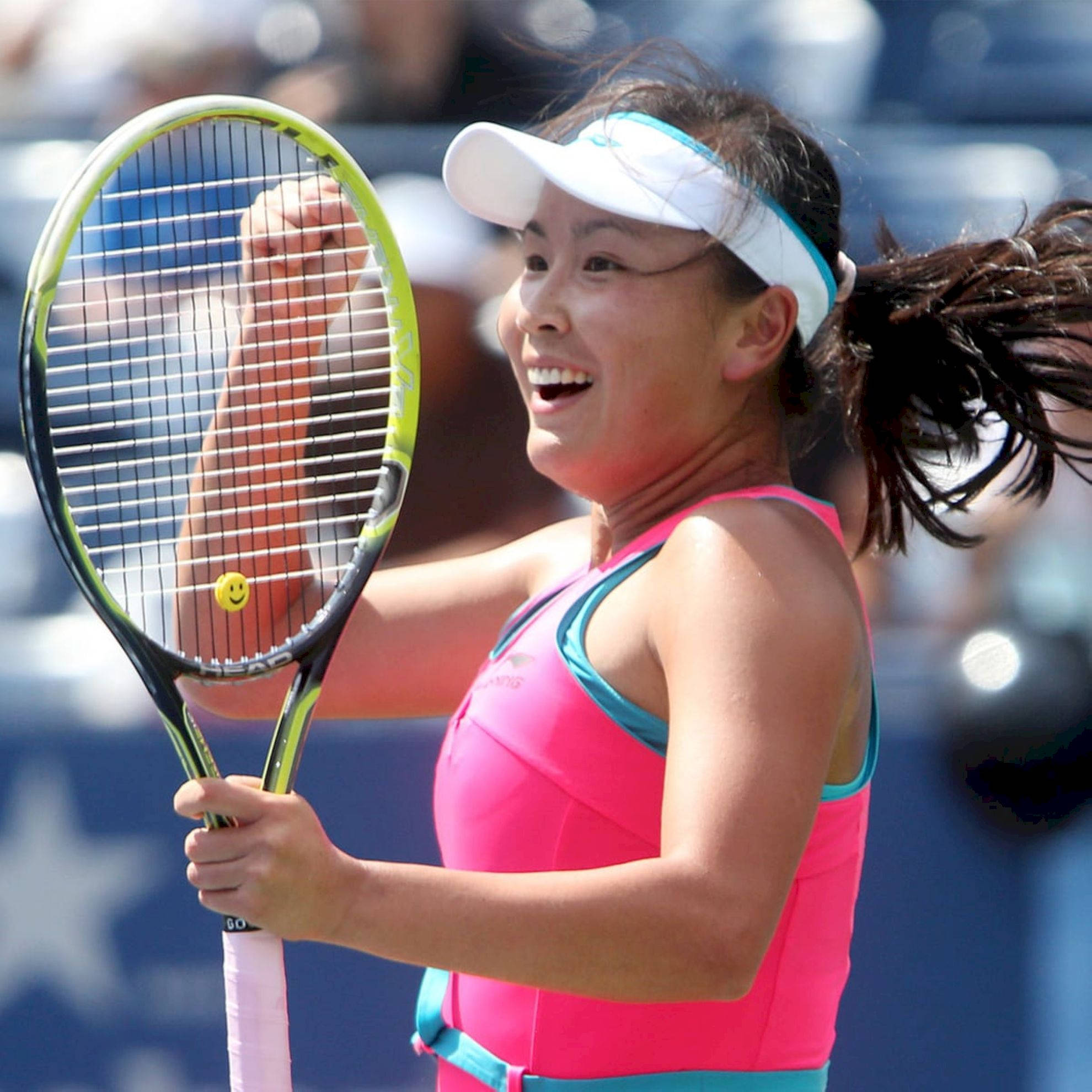 Tennis 桌布 壁紙 — 一位快樂的女網球選手在明亮陽光下高舉球拍慶祝勝利。